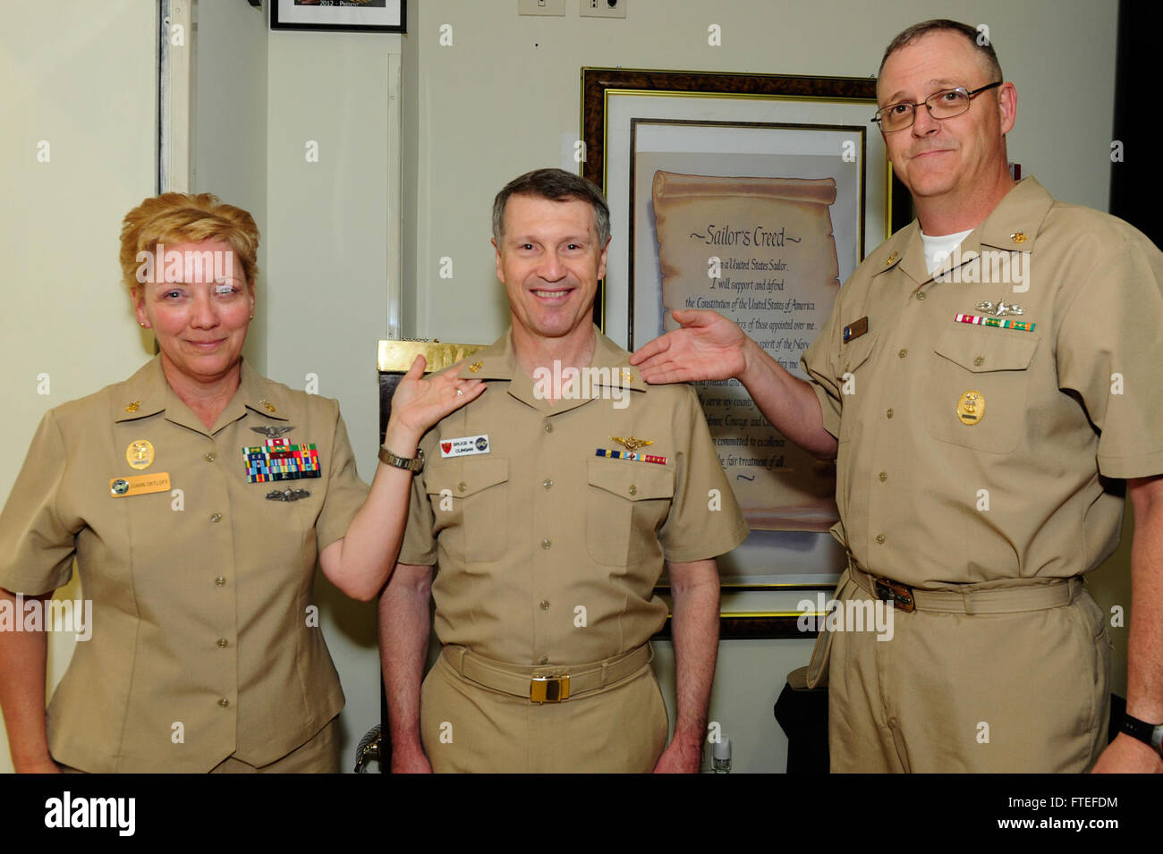 NAPLES, Italy (July 14, 2014) U.S. Naval Forces Europe-Africa Fleet Master Chief JoAnn Ortloff, left, and U.S. 6th Fleet Command Master Chief Charles “Chip” Collins display Commander, U.S. Naval Forces Europe-Africa, Adm. Bruce W. Clingan’s newly pinned Chief’s anchors in the Naples Area Chief Petty Officers Mess. Clingan was named an honorary Chief Petty Officer for his support to Chiefs while serving as Commander, U.S. Naval Forces Europe-Africa and throughout his career. Stock Photo