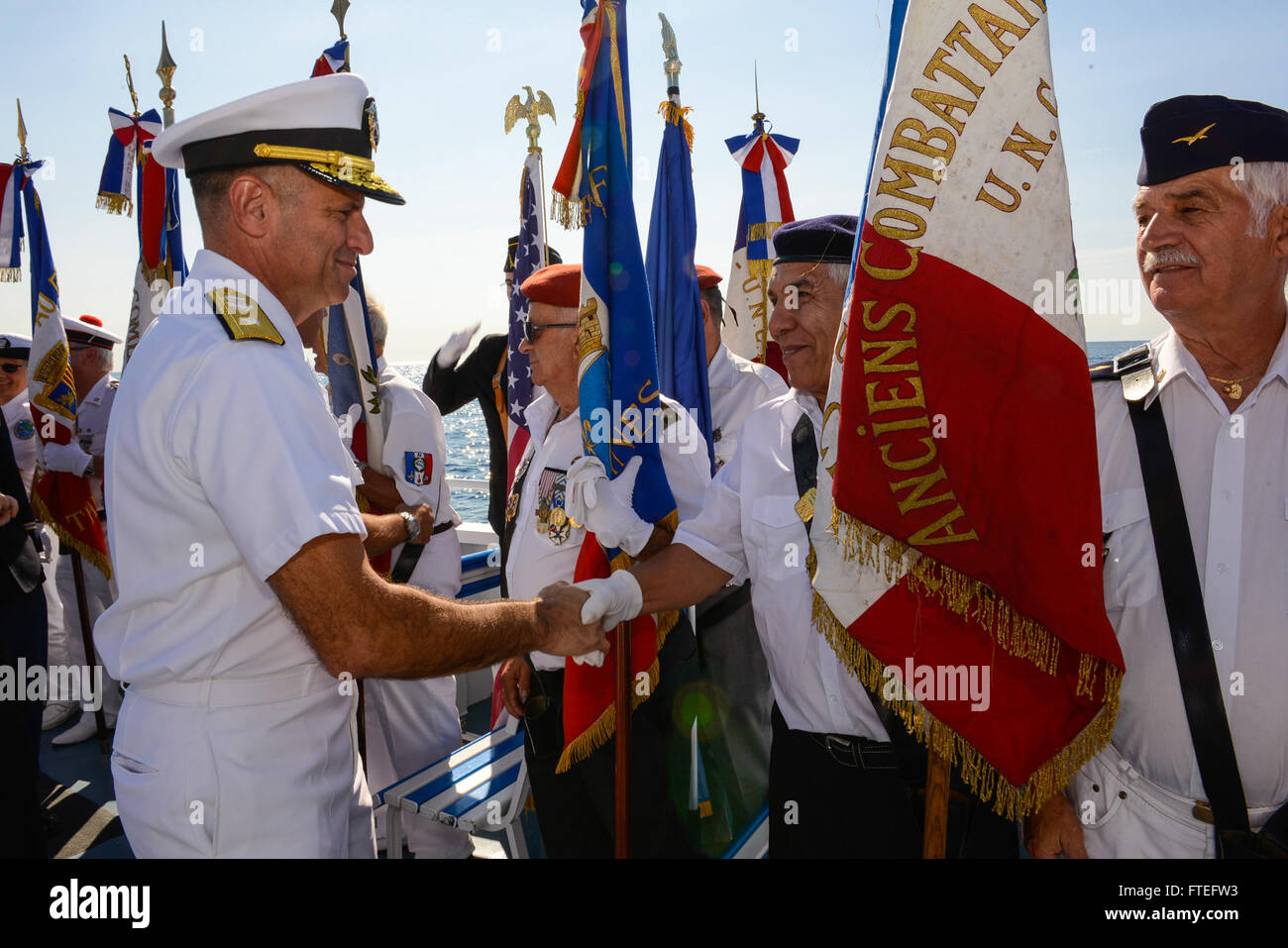 140815-N-UE250-132 GULF OF NAPOULE (Aug. 15, 2014) - Rear Adm. Robert Burke, deputy commander, U.S. 6th Fleet, greats members of the French Veterans Organiztion during a remembrance ceremony at sea. The event was held in commemoration of the 70th Anniversary of Operation Dragoon, which led to the liberation of Southern France by Allied Forces during World War II. (U.S. Navy photo by Mass Communication Specialist 2nd Class Corey Hensley) Stock Photo