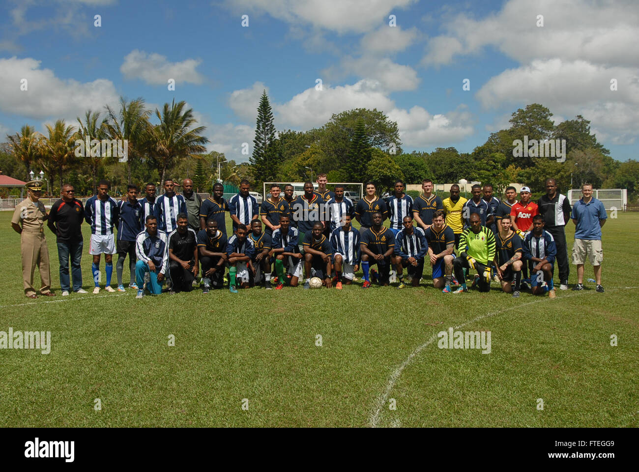 141001-N-GS541-001 PORT LOUIS, Mauritius (Oct. 1, 2014) - Sailors from the Arleigh Burke-class guided-missile destroyer USS James E. Williams (DDG 95) and local Mauritian police force pose for a photo before a friendly game of soccer. James E. Williams, homeported in Norfolk, Va., is conducting naval operations in the U.S. 6th Fleet area of operations in support of U.S. national security interests in Africa. (U.S. Navy photo by Ensign Michael Scarborough) Stock Photo