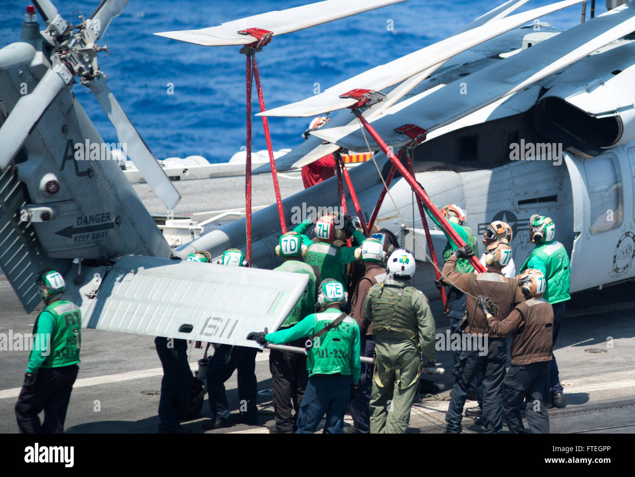 MEDITERRANEAN SEA (August 12, 2013) Sailors, assigned to Helicopter Sea Combat Squadron 7 “Dusty Dogs,” move an MH-60S Sea Hawk helicopter on the flight deck of aircraft carrier USS Harry S. Truman (CVN 75). Harry S. Truman, flagship for Harry S. Truman Carrier Strike Group, is deployed supporting maritime security operations and theater security cooperation efforts in the U.S. 6th Fleet area of responsibility. Stock Photo