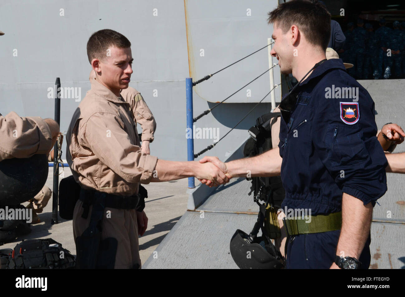 SPLIT, Croatia (Oct. 7, 2014) Aviation Boatswain's Mate (Handling) 2nd Class Travis Starr shakes the hand of a member of the Slovenian navy in front of the amphibious transport dock ship USS Mesa Verde (LPD 19) after participating in a joint visit, board, search and seizure (VBSS) training with members of the Croatian and Slovenian navies during a scheduled port visit. Mesa Verde, part of the Bataan Amphibious Ready Group with the embarked 22nd Marine Expeditionary Unit, is conducting naval operations in the U.S. 6th Fleet area of operations in support of U.S. national secur Stock Photo