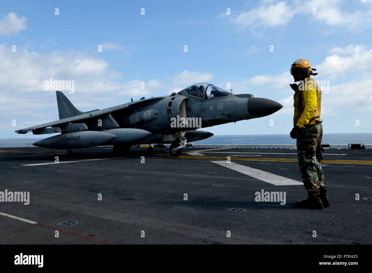 MEDITERRANEAN SEA (Oct. 9, 2014) - Aviation Boatswain's Mate (Handling) 3rd Class Andrew Sterling, from Chicago, directs an AV-8B Italian Harrier aboard the amphibious assault ship USS Bataan (LHD 5). The Bataan Amphibious Ready Group is on a scheduled deployment supporting maritime security operations, providing crisis response capability and theater security cooperation efforts in the U.S. 6th Fleet area of operations. Stock Photo