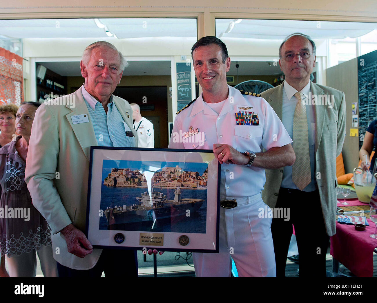 THEOULE-SUR-MER, France (August 13, 2013) Cornelis “Kees” Van Vilet, President of the United States Navy League French Riviera-Monaco Council, receives a gift from Capt. Craig Clapperton, commanding officer of USS Mount Whitney (LCC20) during the Navy League Luncheon at Le Parana Café, Aug. 13. This visit serves to continue U.S. 6th Fleet efforts to build global maritime partnerships with European nations and improve maritime safety and security. Stock Photo