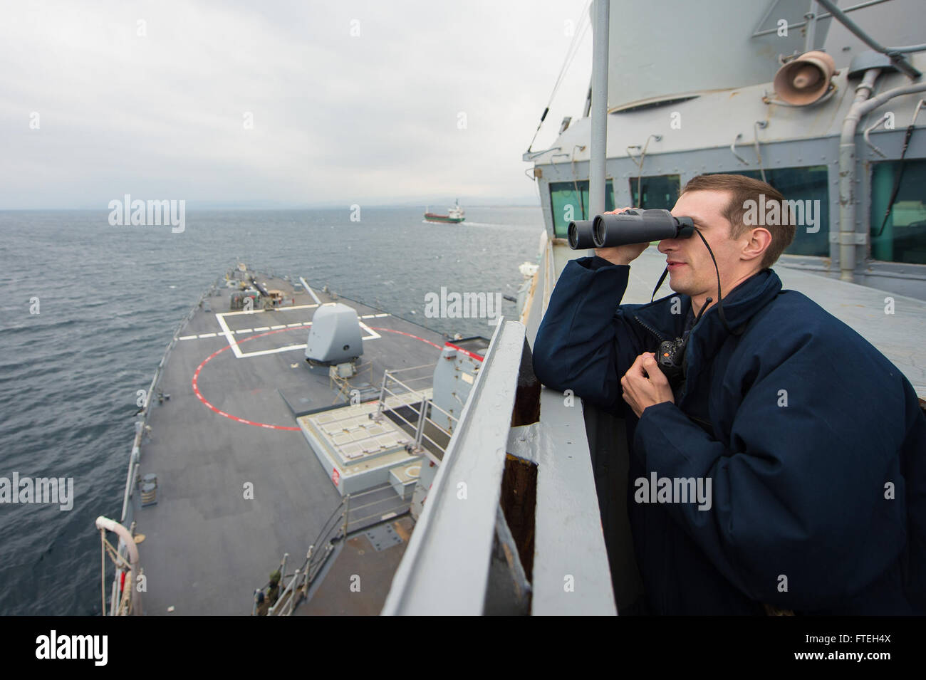 DARDANELLES STRAIT (Oct. 10, 2014) – Ensign Michael Tomsic looks for contacts aboard the Arleigh Burke-class guided-missile destroyer USS Cole (DDG 67) while transiting the Dardanelles strait en route to the Black Sea. Cole, homeported in Norfolk, Va., is conducting naval operations with partners and allies in the U.S. 6th Fleet area of operation in order to advance security and stability in Europe. Stock Photo