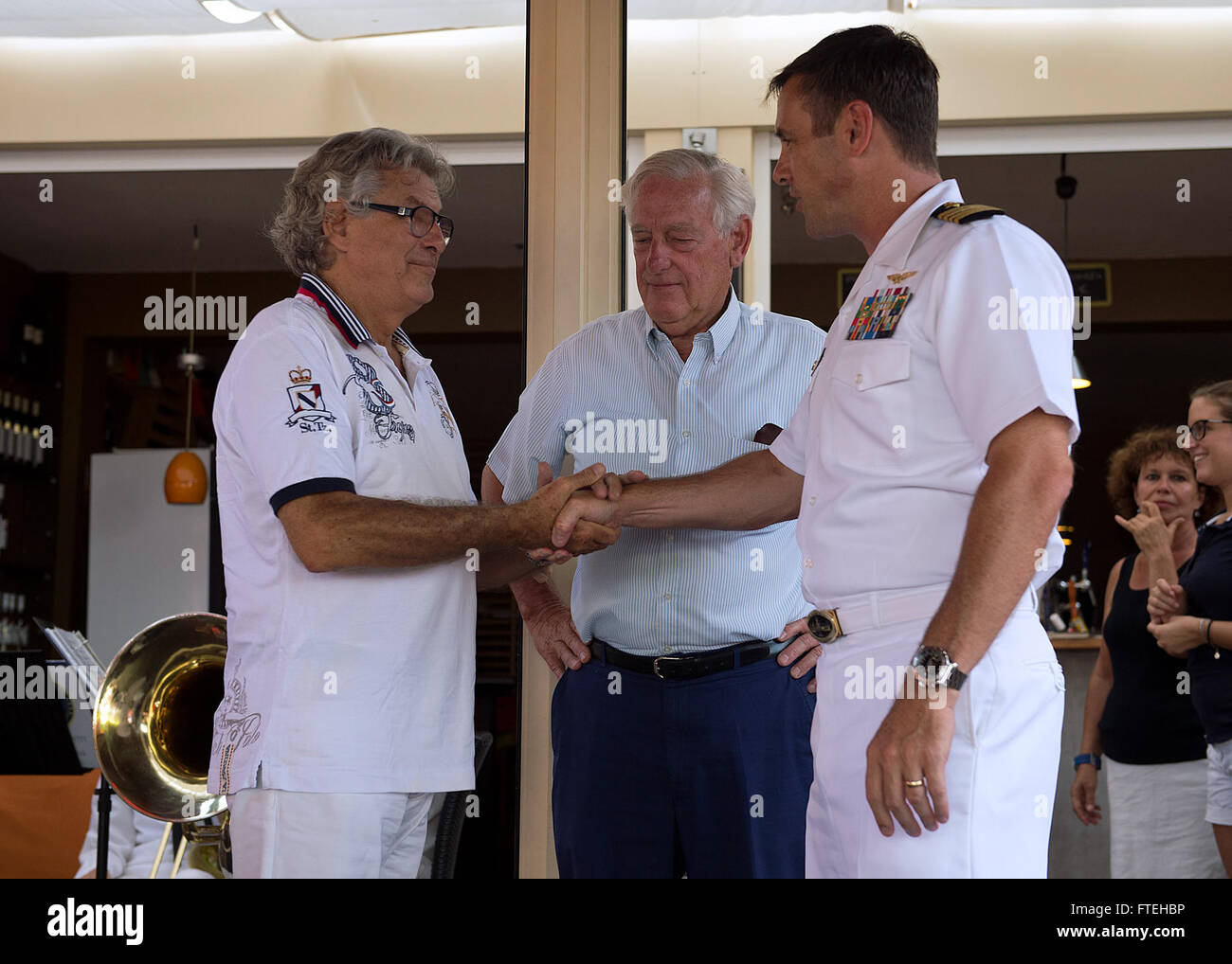 THEOULE-SUR-MER, France (August 13, 2013) Capt. Craig Clapperton, commanding officer of USS Mount Whitney (LCC20), awards a challenge coin to a new member of the United States Navy League French Riviera-Monaco Council during the Navy League Luncheon at Le Parana Café, Aug. 13. This visit serves to continue U.S. 6th Fleet efforts to build global maritime partnerships with European nations and improve maritime safety and security. Stock Photo