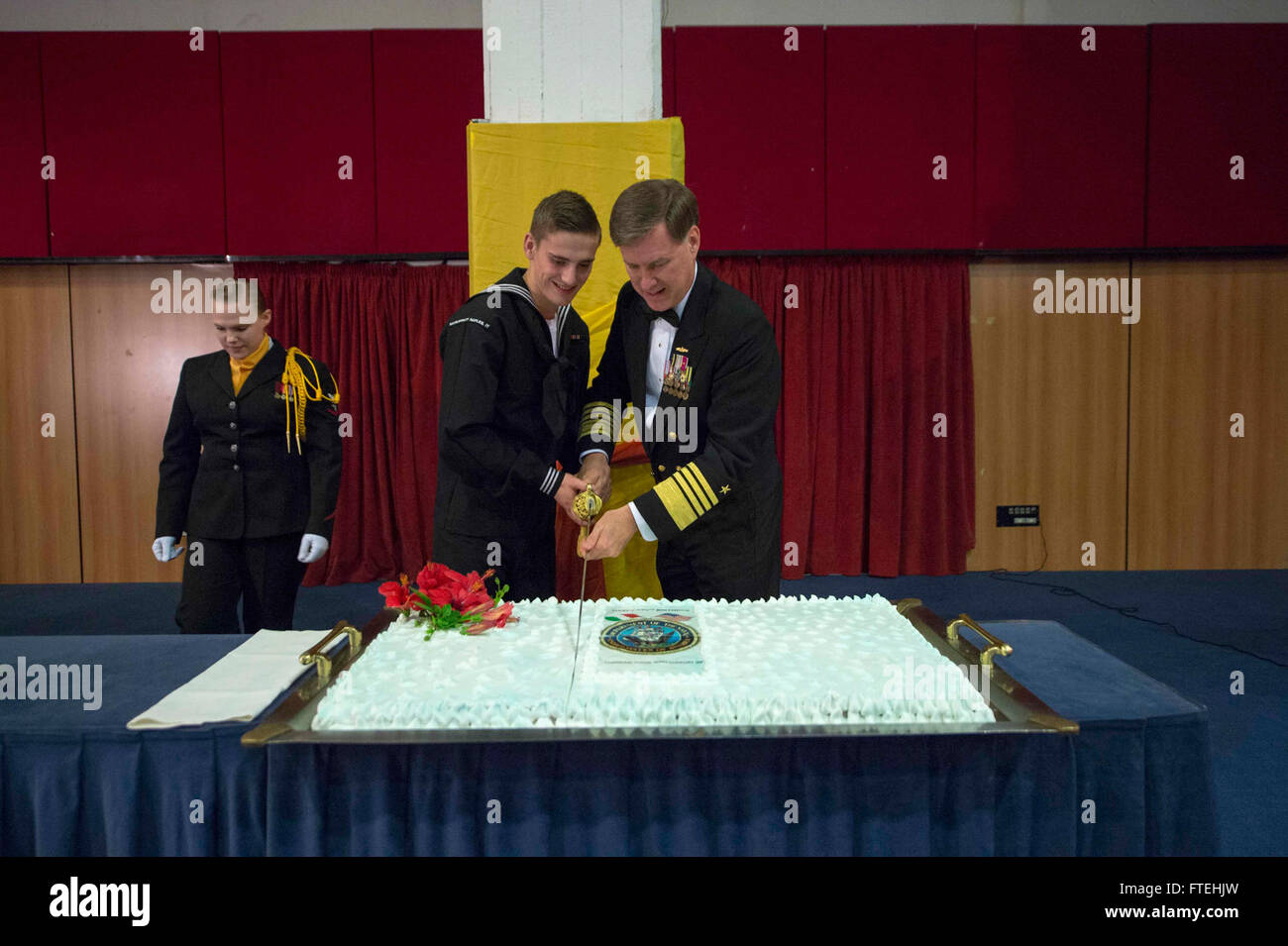 NAPLES, Italy (Oct. 18, 2014) Adm. Mark Ferguson, commander, U.S. Naval Forces Europe-Africa, participates in the Navy tradition of the oldest and youngest Sailors cutting the ceremonial cake during the Naples Area Navy Ball. The theme for this year’s Navy 239th birthday is thanking those who support us. Stock Photo