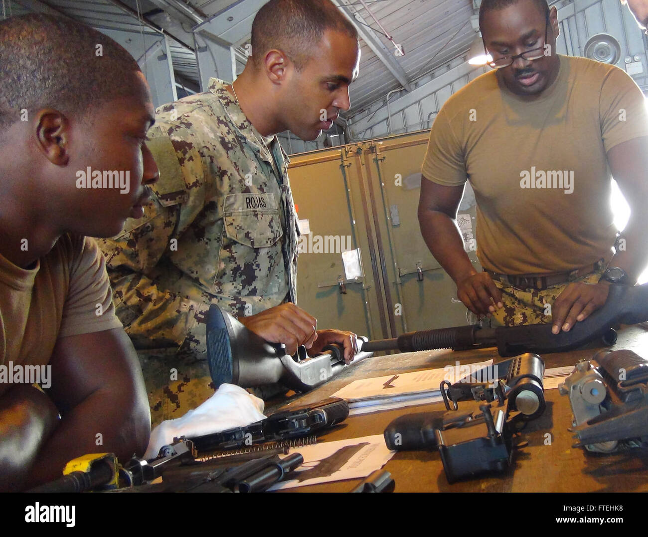 ROTA, Spain – Chief Boatswain’s Mate Cesar Rojas, center, along with other members of Coastal Riverine Squadron 4, receives assembly instructions on the Mossberg M500 shotgun from Gunner’s Mate 1st Class Jerome Claybron as a part of an Expeditionary Warfare training circuit at Naval Station Rota, Spain. Stock Photo
