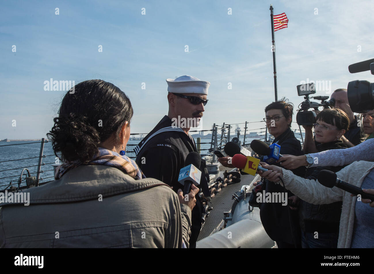 CONSTANTA, Romania (Oct. 22, 2014) – Civilian reporters interview Boatswain’s Mate 2nd Class Alan Farthing aboard the Arleigh Burke-class guided-missile destroyer USS Cole (DDG 67) during a scheduled port visit. Cole, homeported in Norfolk, Va., is conducting naval operations in the U.S. 6th Fleet area of operations in support of U.S. national security interests in Europe. Stock Photo