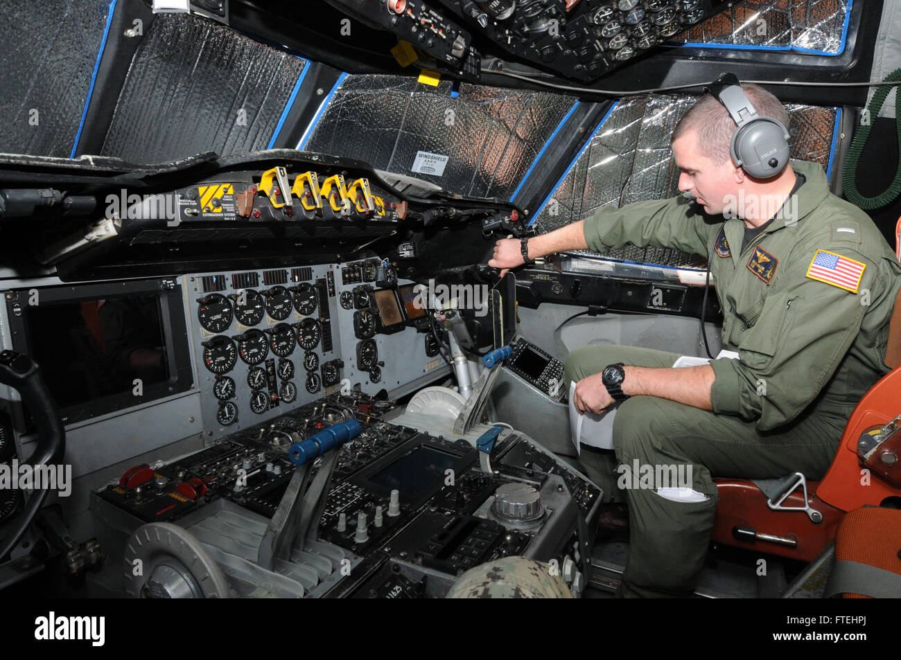 SIGONELLA, Sicily (Oct. 28, 2014) – Lt. j.g. Ryan Miller assigned to Patrol Squadron FOUR (VP 4) checks the intercommunications system of a P-3C Orion maritime patrol aircraft during pre-flight. VP 4 is conducting naval operations in the U.S. 6th Fleet area of operations in support of U.S. national security interests in Europe. Stock Photo