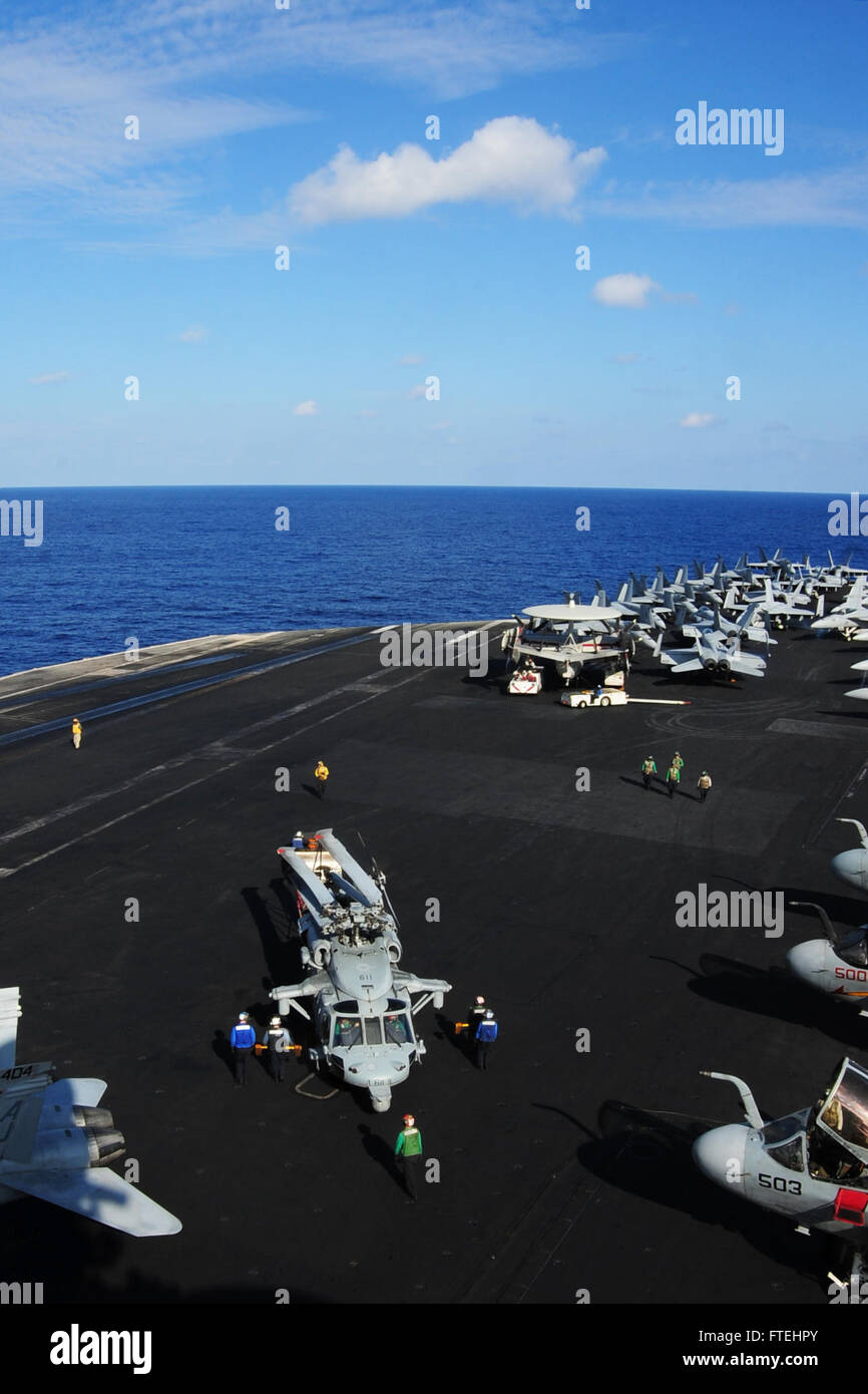 MEDITERRANEAN SEA (Oct. 28, 2014) Sailors move an MH-60S Sea Hawk, attached to the “Tridents” of Helicopter Sea Combat Squadron (HSC) 9, on flight deck of the aircraft carrier USS George H.W. Bush (CVN 77). George H.W. Bush, homeported in Norfolk, Va., is conducting naval operations in the U.S. 6th Fleet area of operations in support of U.S. national security interests in Europe. Stock Photo