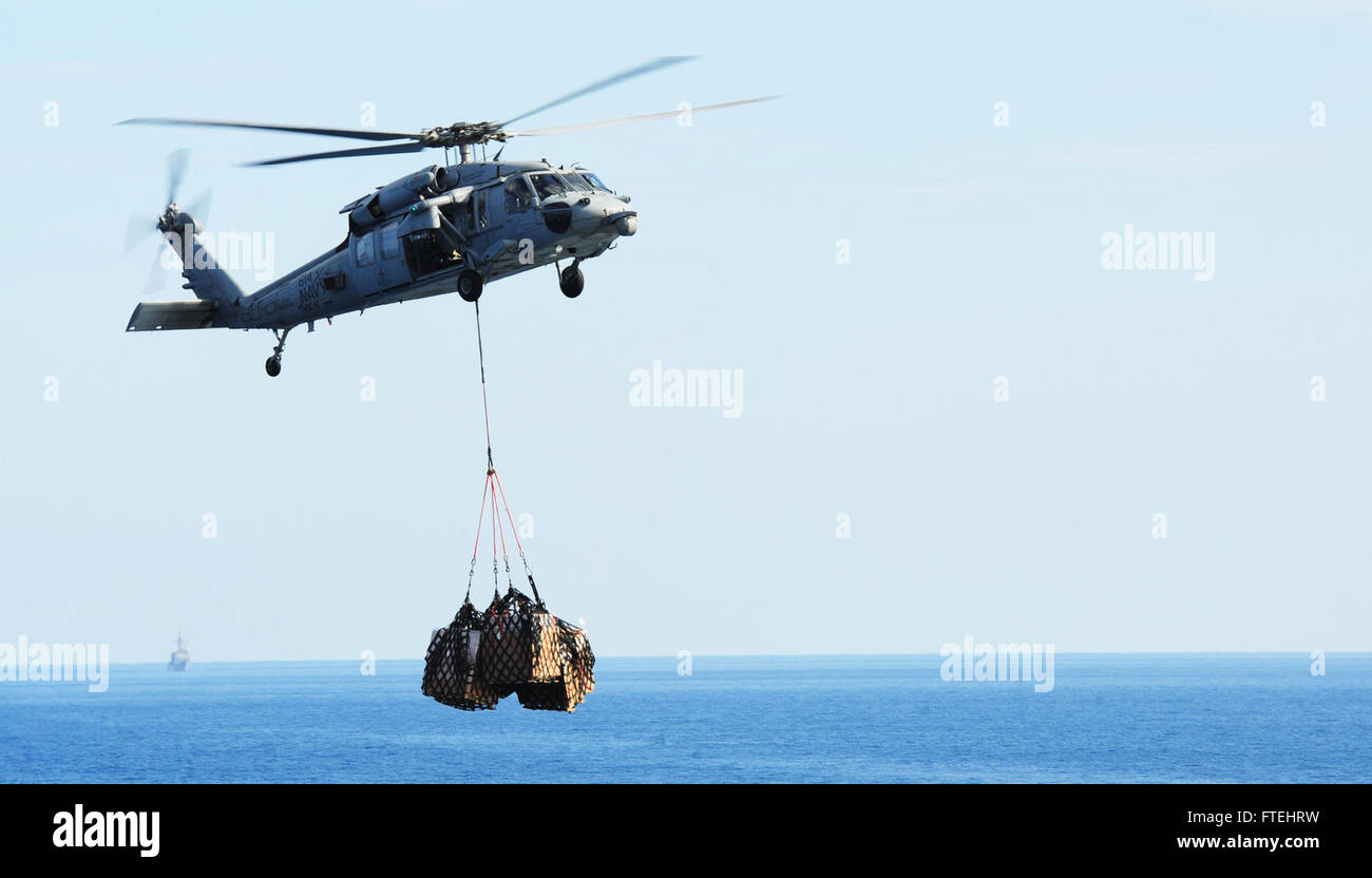 MEDITERRANEAN SEA (Oct. 28, 2014) An MH-60S Sea Hawk, attached to the “Tridents” of Helicopter Sea Combat Squadron (HSC) 9, transports cargo to the flight deck of the aircraft carrier USS George H.W. Bush (CVN 77). George H.W. Bush, homeported in Norfolk, Va., is conducting naval operations in the U.S. 6th Fleet area of operations in support of U.S. national security interests in Europe. Stock Photo