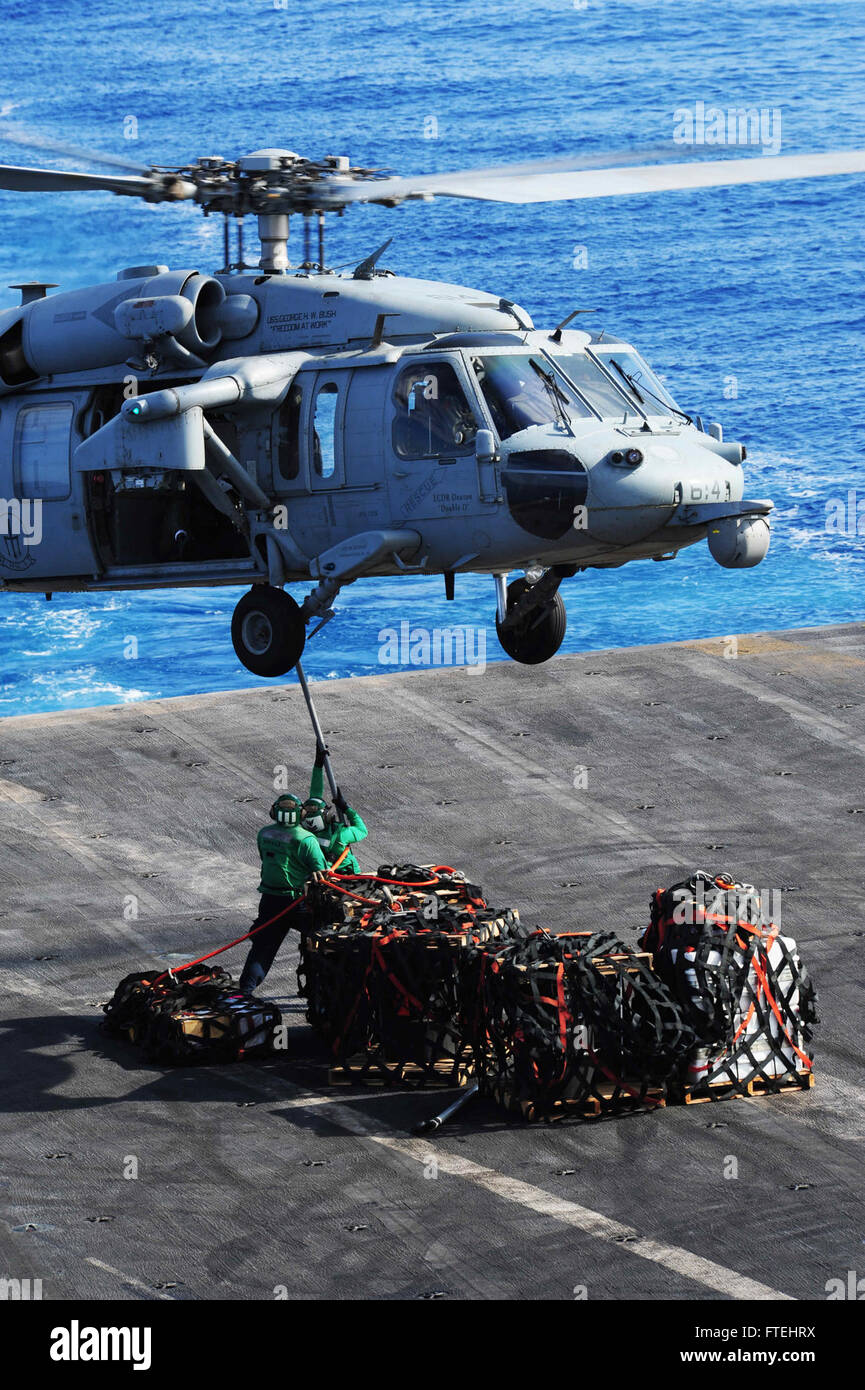 MEDITERRANEAN SEA (Oct. 28, 2014) Sailors attached cargo to an MH-60S Sea Hawk, attached to the “Tridents” of Helicopter Sea Combat Squadron (HSC) 9, on the flight deck of the aircraft carrier USS George H.W. Bush (CVN 77). George H.W. Bush, homeported in Norfolk, Va., is conducting naval operations in the U.S. 6th Fleet area of operations in support of U.S. national security interests in Europe. Stock Photo
