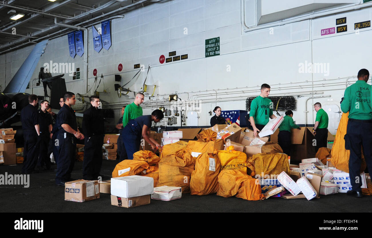 MEDITERRANEAN SEA (Oct. 28, 2014) Sailors organize mail in the hangar bay of the aircraft carrier USS George H.W. Bush (CVN 77). George H.W. Bush, homeported in Norfolk, Va., is conducting naval operations in the U.S. 6th Fleet area of operations in support of U.S. national security interests in Europe. Stock Photo