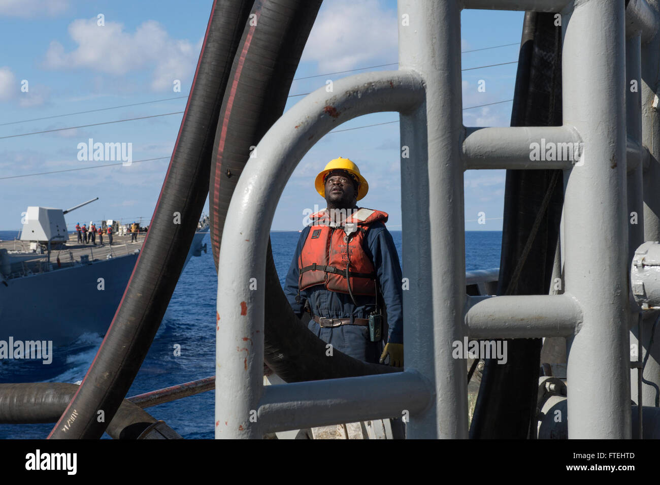 MEDITERRANEAN SEA (Oct. 28, 2014) - A civil service mariner works on the weather deck the fleet replenishment oiler USNS Leroy Grumman (T-AO 195) during an underway replenishment-at-sea with the Arleigh-Burke Class Destroyer USS Truxtun (DDG 103). Grumman, the Military Sealift Command Mediterranean Sea duty oiler, is forward-deployed to the U.S. 6th Fleet area of operations in support of national security interests in Europe and Africa. Stock Photo