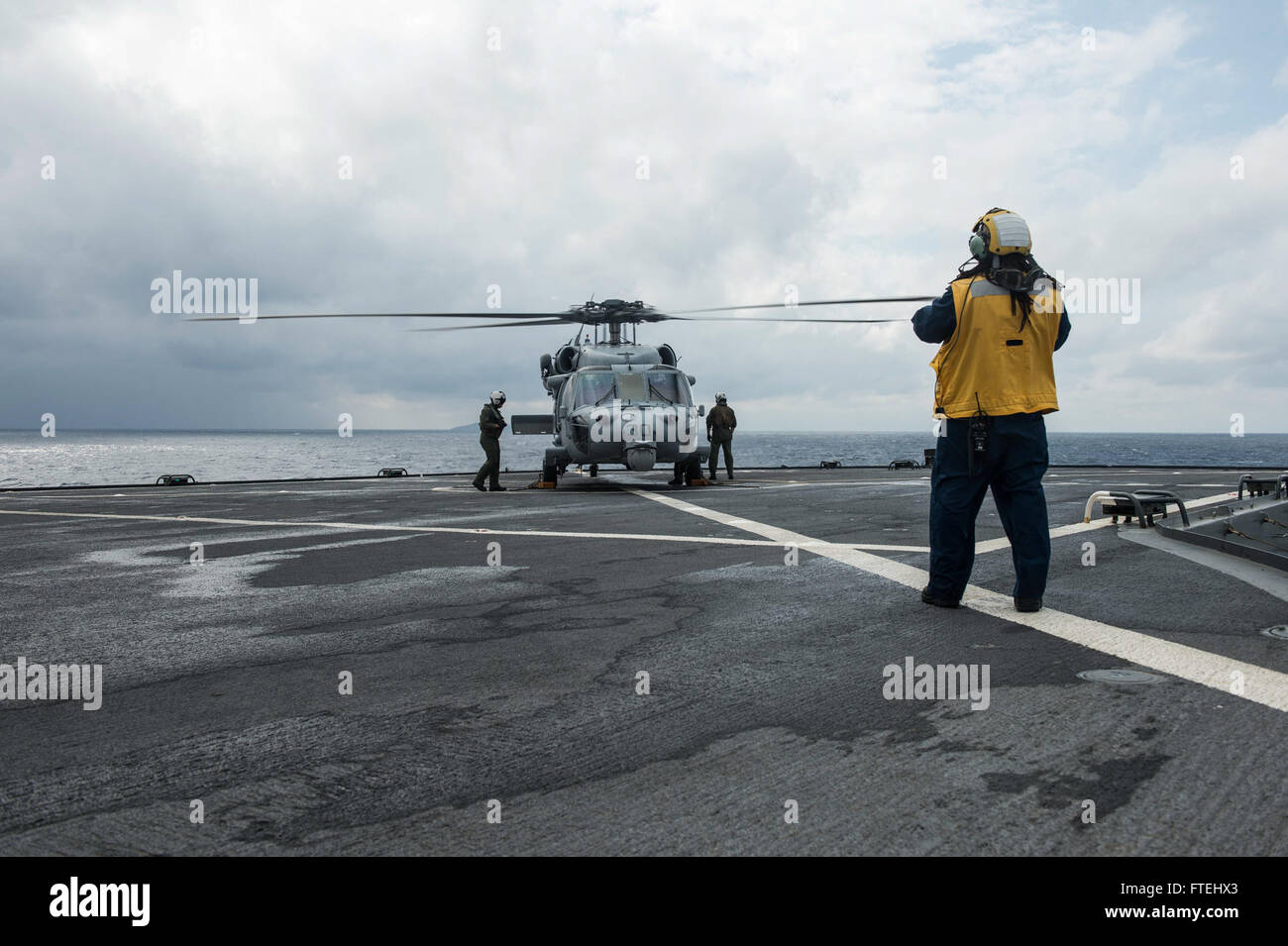 MEDITERRANEAN SEA (Oct. 29, 2014) – Marion Malley signals an MH-60S Sea Hawk helicopter assigned to the Ghostriders of Helicopter Sea Combat Squadron (HSC 28), Detachment 1, aboard the 6th fleet command and control ship USS Whitney (LCC 20). Mount Whitney is conducting naval operations with allies and partners in the U.S. 6th Fleet area of operations in order to advance security and stability in Europe. Stock Photo