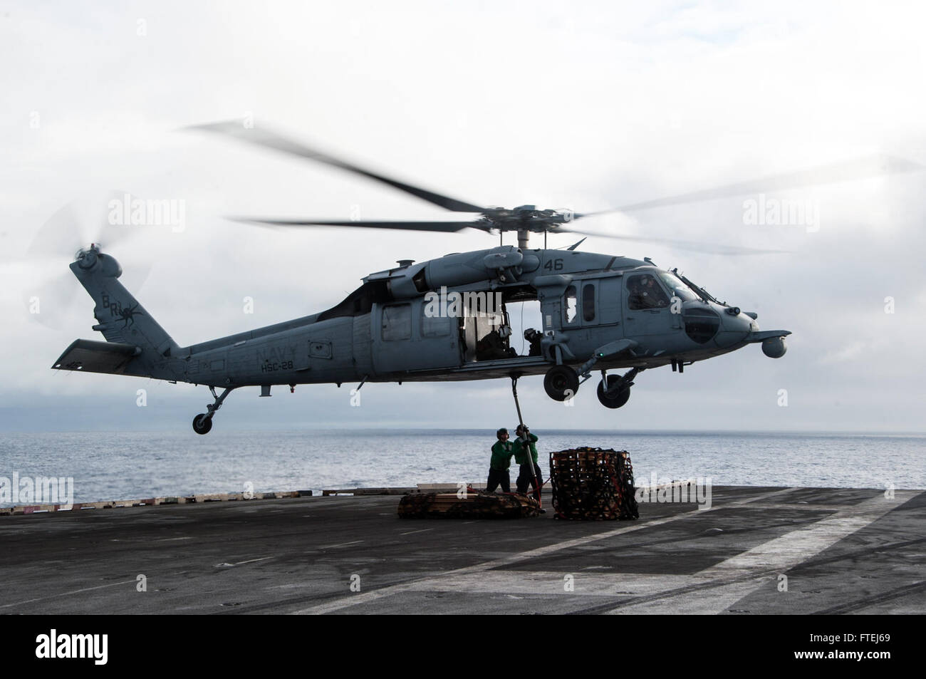 ATLANTIC OCEAN (Nov. 7, 2014) An MH-60S Sea Hawk, attached to the &quot;Dragon Whales&quot; of Helicopter Sea Combat Squadron (HSC) 28, conducts a vertical replenishment (VERTREP) with the aircraft carrier USS George H.W. Bush (CVN 77). George H.W. Bush, homeported in Norfolk, Va., is conducting naval operations in the U.S. 6th Fleet area of operations in support of U.S. national security interests in Europe.  (U.S. Navy photo by Mass Communication Specialist 3rd Class Brian Stephens/Released) Stock Photo