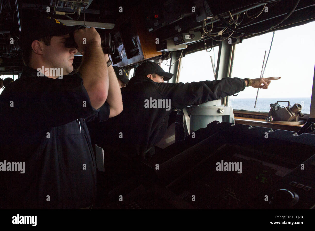 MEDITERRANEAN SEA (November 9, 2014) – Ensign Dustin Baker points out range and bearing to Ensign David Mahoney aboard the Arleigh Burke-class guided-missile destroyer USS Cole (DDG 67) during exercise Mavi Balina. Exercise Mavi Balina is a biennial Turkish-led anti-submarine warfare maritime exercise involving NATO and regional forces in the eastern Mediterranean to improve interoperability and increase tactical proficiencies. Stock Photo