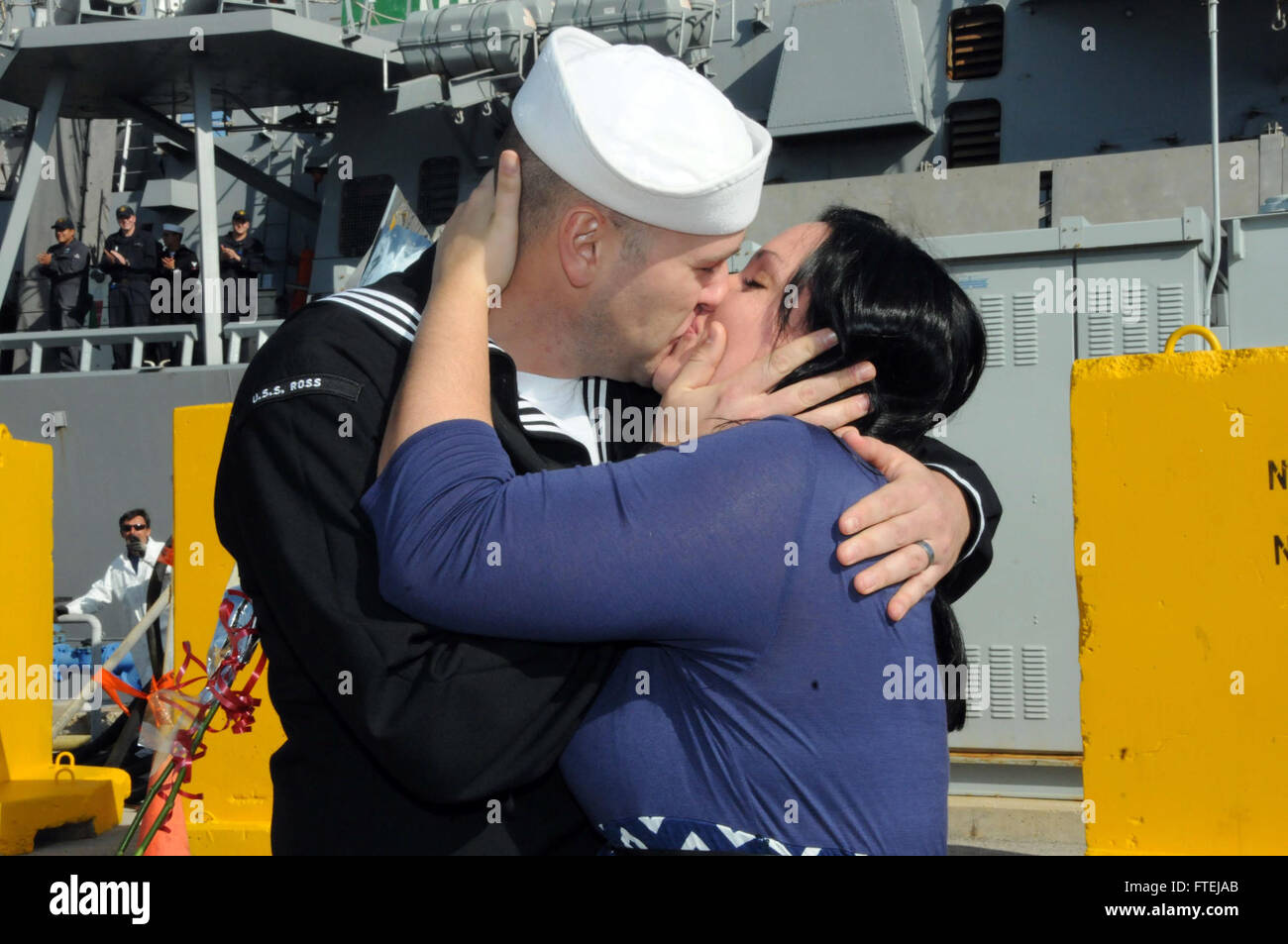 NAVAL STATION ROTA, Spain (Nov. 18, 2014) - Fire Controlman 2nd Class Brian Beddoes, of Harrison, Minnesota, kisses his wife, Kaitlyn, following the ships return to Naval Station Rota after its first patrol since being forward-deployed to Europe. Ross, an Arleigh Burke-class guided missile destroyer forward deployed in Rota Spain, returned from conducting naval operations in the U.S. 6th Fleet area of operations in support of U.S. national security interests in Europe. Stock Photo