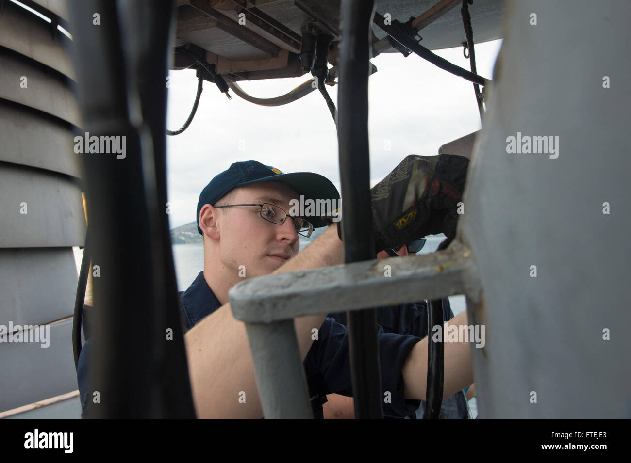 SOUDA BAY, Greece (Nov. 26, 2014) – Fire Controlman 3rd Class Landrel Hankins, from Mountain View, Arkansas, conducts preservation work on combat systems equipment aboard USS Cole (DDG 67) during a voyage-maintenance availability in Souda Bay, Greece, Nov. 26. Cole, an Arleigh Burke-class guided-missile destroyer, homeported in Norfolk, is conducting naval operations in the U.S. 6th Fleet area of operations in support of U.S. national security interests in Europe. Stock Photo