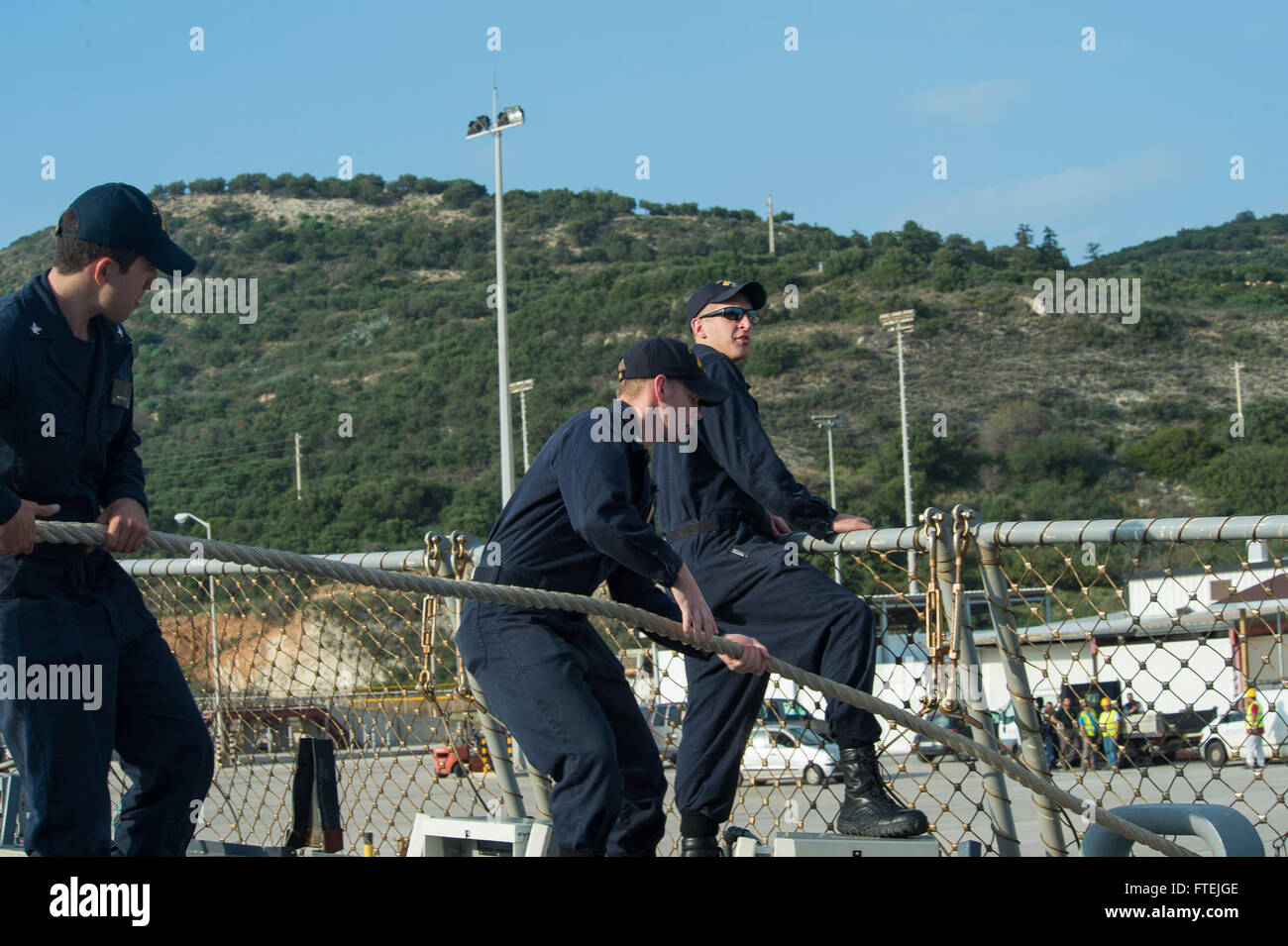 SOUDA BAY, Greece (Dec. 4, 2014) Sailors heave in mooring lines aboard USS Cole (DDG 67) as the ship departs Souda Bay following a scheduled port visit, Dec. 4, 2014. Cole, an Arleigh Burke-class guided-missile destroyer, homeported in Norfolk, is conducting naval operations in the U.S. 6th Fleet area of operations in support of U.S. national security interests in Europe. Stock Photo