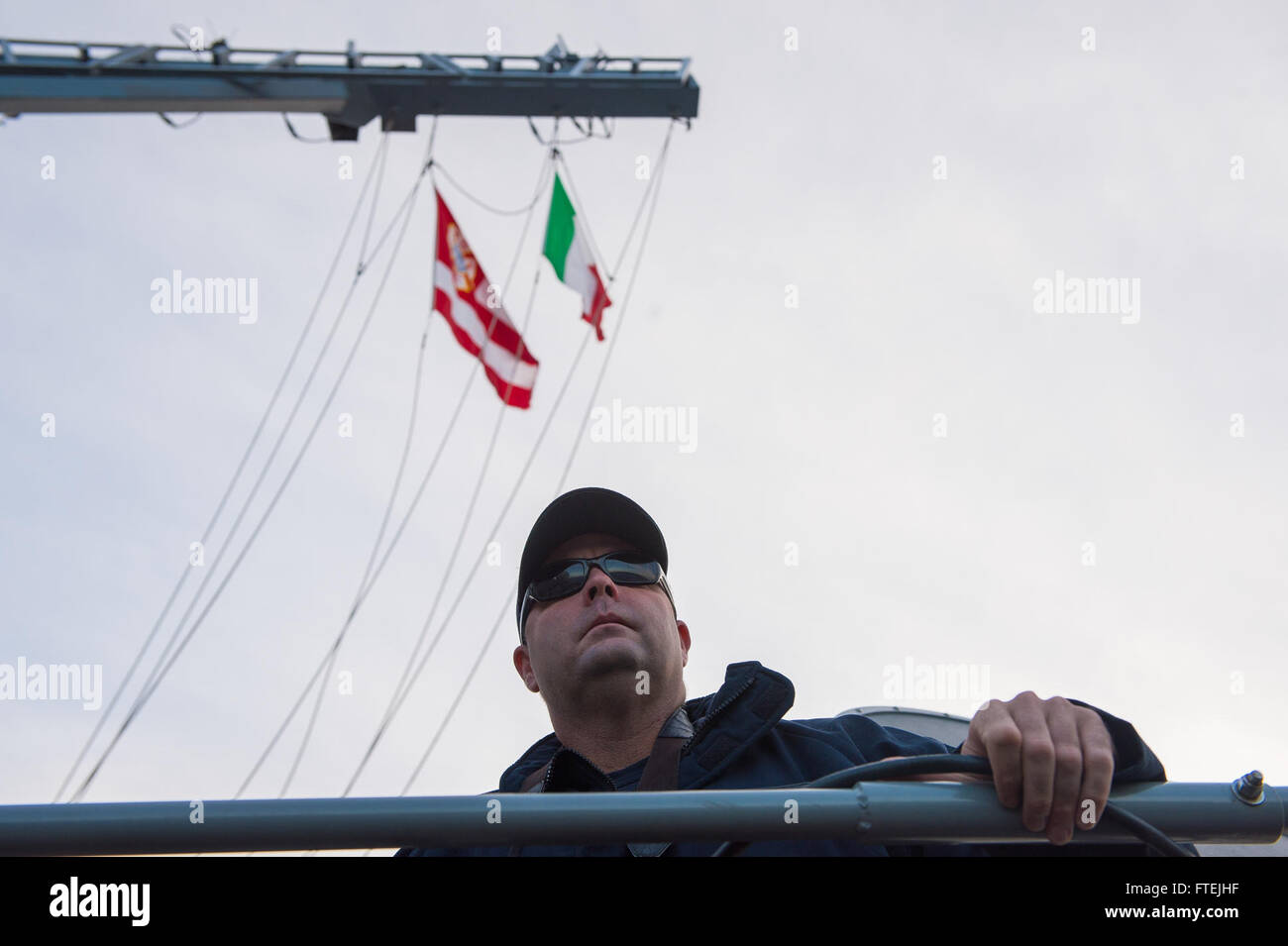 AUGUSTA BAY, Sicily (Dec. 8, 2014) Cmdr. Dennis Farrell, commanding officer, USS Cole (DDG 67), stands on the bridge as the ship pulls in to Augusta Bay, Sicily, during a scheduled port visit Dec. 8, 2014. Cole, an Arleigh Burke-class guided-missile destroyer, homeported in Norfolk, is conducting naval operations in the U.S. 6th Fleet area of operations in support of U.S. national security interests in Europe. Stock Photo