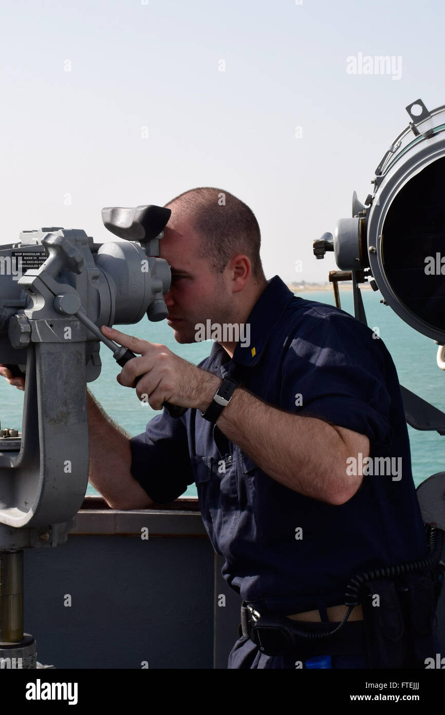SUEZ CANAL (Dec. 12, 2014) Ensign Kyle Moros from Port Everglades, Florida, looks at a surface contact through the “Big Eyes” binoculars aboard USS Oscar Austin (DDG 79). Oscar Austin, an Arleigh Burke-class guided-missile destroyer, homeported in Norfolk, is conducting naval operations in the U.S. 6th Fleet area of operations in support of U.S. national security interests in Europe and Africa. Stock Photo