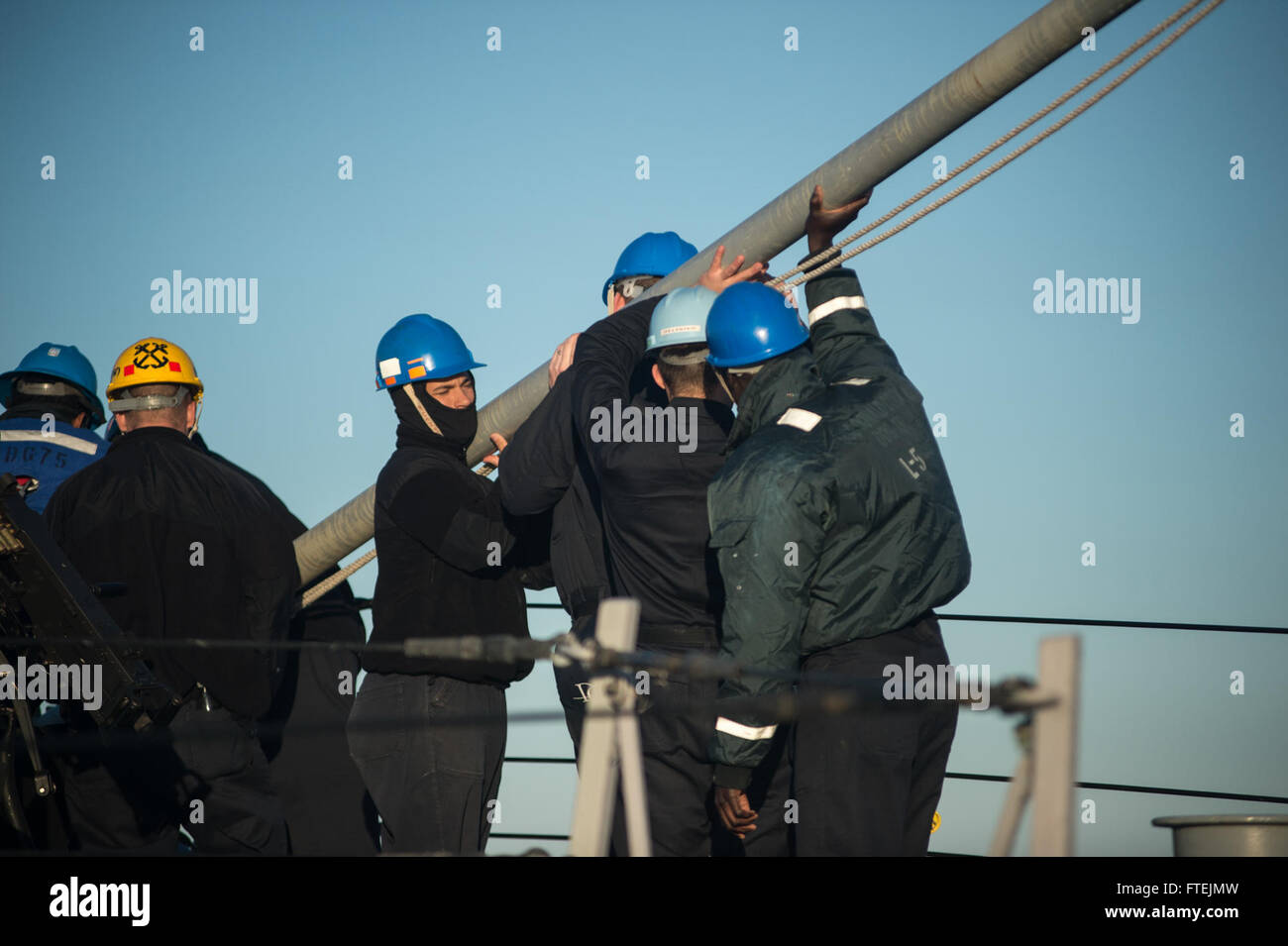 MEDITERRANEAN SEA (Dec. 20, 2014) Sailors assigned to USS Donald Cook (DDG 75), mount the flagstaff as the ship prepares to pull in to Augusta Bay for a port visit Dec. 20, 2014. Donald Cook, an Arleigh Burke-class guided-missile destroyer, forward-deployed to Rota, Spain, is conducting naval operations in the U.S. 6th Fleet area of operations in support of U.S. national security interests in Europe. Stock Photo