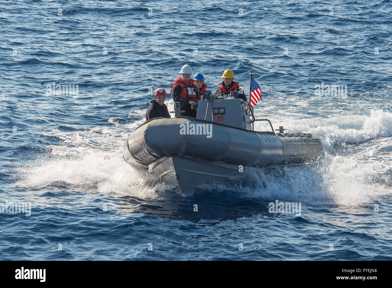 MEDITERRANEAN SEA (Dec. 21, 2014) Boatswain’s Mate 2nd Class Ian Sutton, from Ottawa, Kansas, maneuvers a rigid-hull inflatable boat alongside USS Cole (DDG 67) during a passenger transfer with USNS Kanawha (T-AO 196), Dec. 21, 2014. Cole, an Arleigh Burke-class guided-missile destroyer, and Kanawha, a Henry J. Kaiser-class fleet replenishment oiler, are conducting naval operations in the U.S. 6th Fleet area of operations in support of U.S. national security interests in Europe. Stock Photo