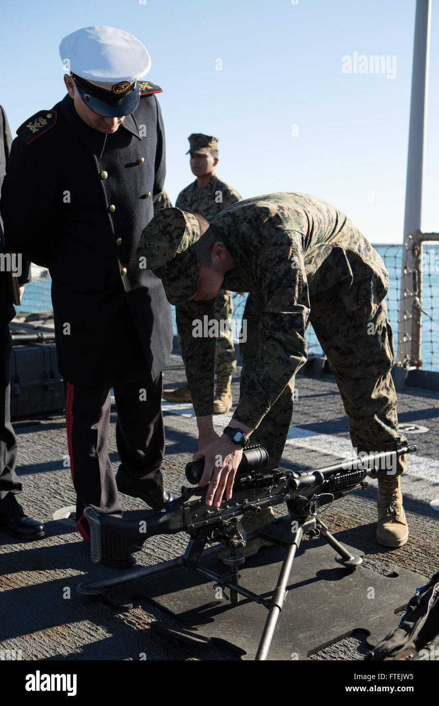 VALENCIA, Spain (Dec. 31, 2014) A Marine with Battalion Landing Team 3rd Battalion, 6th Marine Regiment, 24th Marine Expeditionary Unit, shows an M240B machine gun to a Spanish military official aboard the USS Fort McHenry (LSD 43) in Valencia, Spain, Dec. 31, 2014. The 24th MEU and Iwo Jima Amphibious Ready Group are conducting naval operations in the U.S. 6th Fleet area of operations in support of U.S. national security interests in Europe. Stock Photo