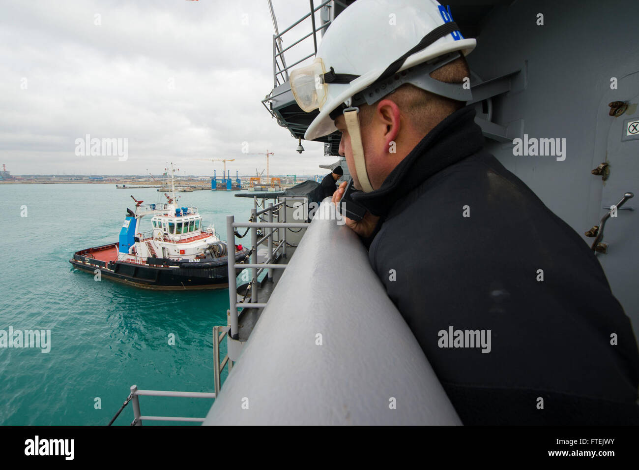 CIVITAVECCHIA, Italy (Jan. 3, 2015) Chief Boatswain's Mate Brandon Bonin, a native of New Iberia, Louisiana, observes a tug boat, while relaying instructions to the bridge as amphibious assault ship USS Iwo Jima (LHD 7) depart Civitavecchia, Italy, Jan. 3, 2015. Iwo Jima pulled in to Civitavecchia Dec. 30 for a scheduled port visit before continuing its deployment in support of maritime security operations and theater security cooperation efforts in the U.S. 6th Fleet areas of operations. Stock Photo