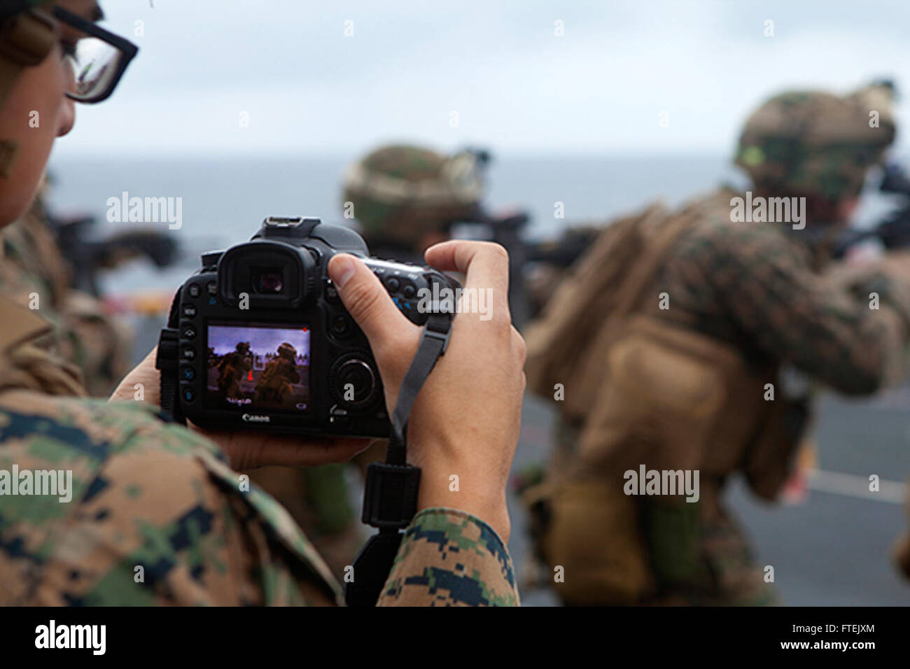 MEDITERRANEAN SEA (Jan. 4, 2015) Lance Cpl. Dani A. Zunun, a combat videographer assigned to 24th Marine Expeditionary Unit, captures video imagery during a live-fire exercise on the flight deck aboard USS Iwo Jima Jan. 4, 2015. The 24th MEU and Iwo Jima Amphibious Ready Group are conducting naval operations in the U.S. 6th Fleet area of operations in support of U.S. national security interests in Europe. Stock Photo