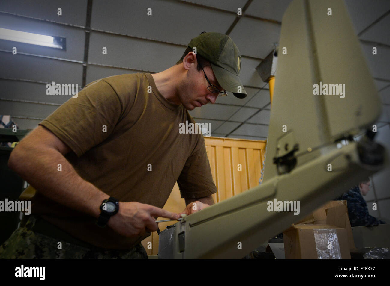 150110-N-RB579-032 ATLANTIC OCEAN (Jan. 10, 2015) Intelligence Specialist 2nd Class Joshua Lesperance conducts routine maintenance on the small unmanned aircraft system RQ-20A Aqua Puma aboard USNS Spearhead (JHSV 1), Jan. 10, 2015. Spearhead is on a scheduled deployment in the U.S. 6th Fleet area of operations to support the international collaborative capacity-building program Africa Partnership Station. (U.S. Navy photo by Mass Communication Specialist 1st Class Joshua Davies/Released) Stock Photo