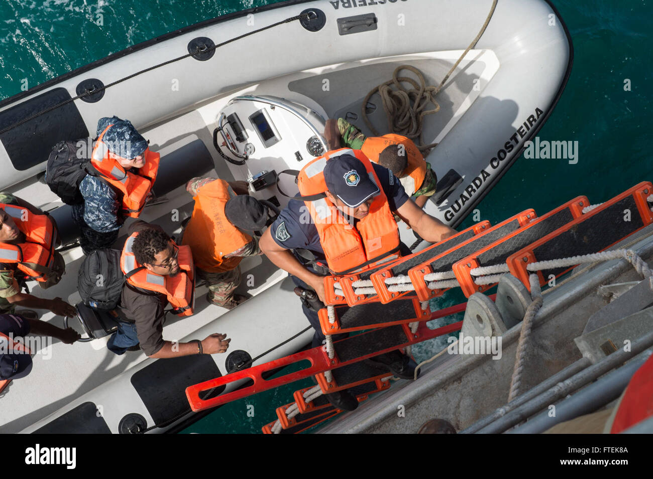 A member of the Cabo Verde Coast Guard climbs aboard the USNS Spearhead ...