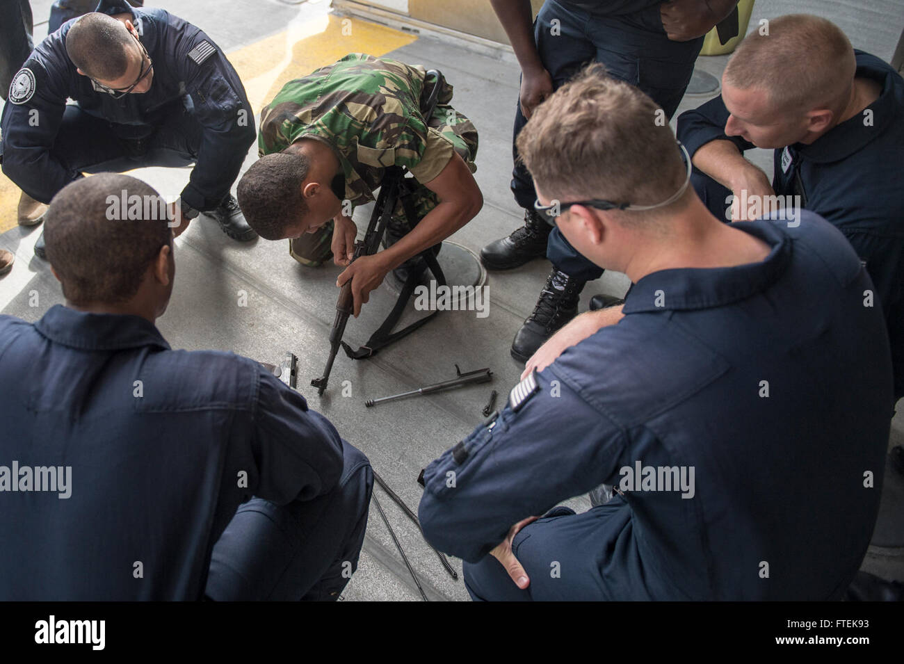 150114-N-JP249-073 ATLANTIC OCEAN (Jan. 14, 2015) Members of the Cabo Verde Coast Guard and the U.S. Coast Guard’s Law Enforcement Detachment 407 practice disassembling an AK-47 machine gun aboard the Military Sealift Command’s joint high-speed vessel USNS Spearhead (JHSV 1), Jan. 14, 2015. Spearhead is on a scheduled deployment to the U.S. 6th Fleet area of operations in support of the international collaborative capacity-building program Africa Partnership Station. (U.S. Navy photo by Mass Communication Specialist 2nd Class Kenan O’Connor/Released) Stock Photo