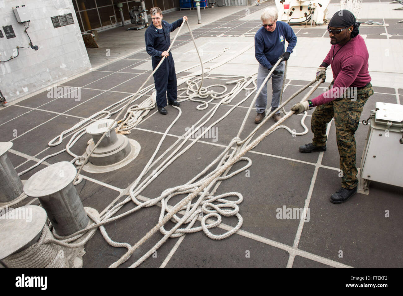 DAKAR, Senegal (Jan. 24, 2015) Sailors and Military Sealift Command civil service mariners haul in lines in preparation to get underway, while  aboard the Military Sealift Command’s joint high-speed vessel USNS Spearhead (JHSV 1) Jan. 24, 2015. Spearhead is on a scheduled deployment to the U.S. 6th Fleet area of operations to support the international collaborative capacity-building program Africa Partnership Station. Stock Photo