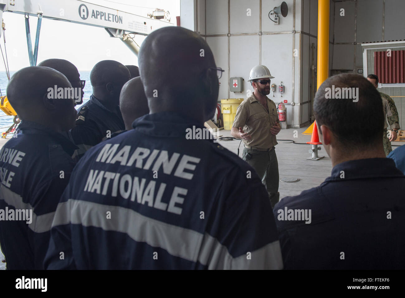 ATLANTIC OCEAN (Jan. 24, 2015) Military Sealift Command civil service mariner Chief Mate James Regan addresses a group of U.S. Navy Sailors, U.S. Coast Guardsmen and members of the Senegal military before conducting a training mission aboard the Military Sealift Command’s joint high-speed vessel USNS Spearhead (JHSV 1) Jan. 24, 2015. Spearhead is on a scheduled deployment to the U.S. 6th Fleet area of operations to support the international collaborative capacity-building program Africa Partnership Station. Stock Photo