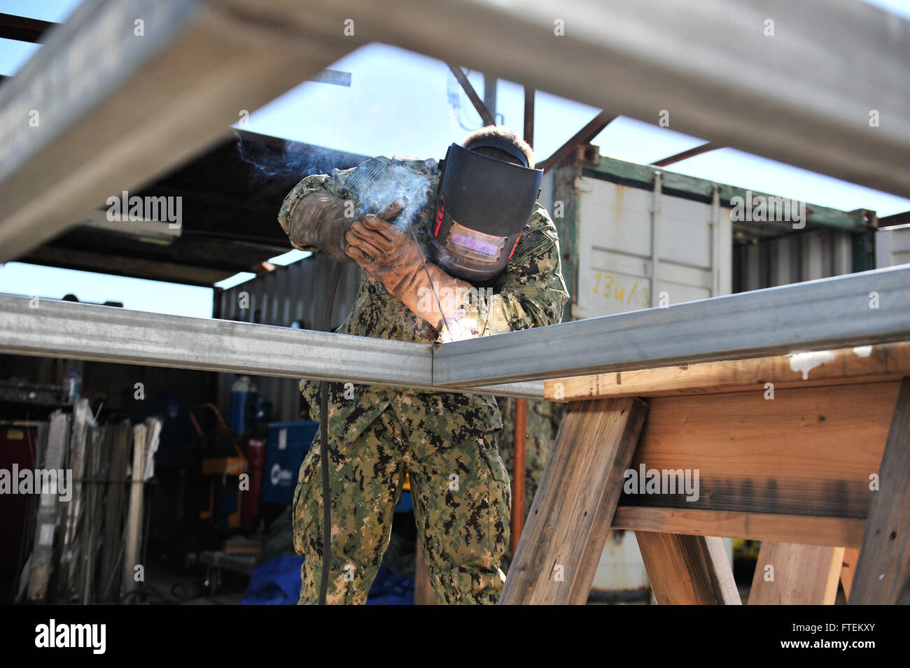 NAVAL STATION ROTA, Spain (Feb. 13, 2015) Steelworker 3rd Class Shawn Hoagland assigned to Naval Mobile Construction Battalion (NMCB) 11, welds two pieces of metal together for a door on a upcoming project Feb. 13, 2015. NMCB 11 is currently deployed to 14 different detachment sites throughout European Command, African command, Pacific Command and Central Command; promoting security and stability by conducting general engineering, disaster relief, construction readiness operations and Human civic action support. (U.S. Navy photo by Mass Communication Specialist 1st Class Mic Stock Photo