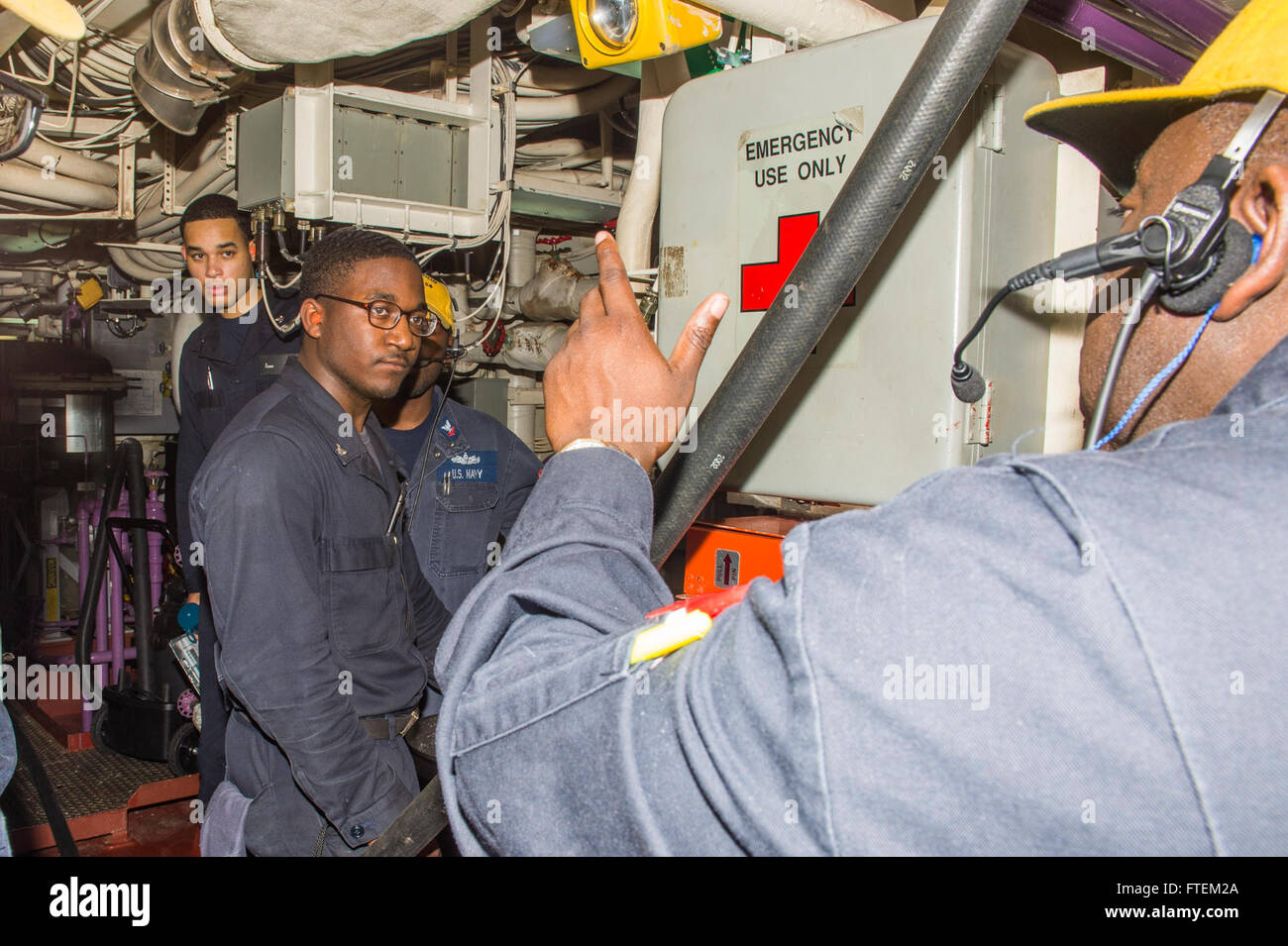 ATLANTIC OCEAN (Feb. 19, 2015) Chief Gas Turbine System Technician Damian Bethel from Miami, right, instructs Sailors, including Gas Turbine Systems Technician 3rd Class Jaylun Nowden, center, on proper firefighting procedures for a Class B fire Feb. 19, 2015. Laboon, an Arleigh Burke-class guided-missile destroyer home ported in Norfolk, is underway conducting naval operations in the U.S. 6th Fleet area of operations in support of U.S. national security interests in Europe. Stock Photo