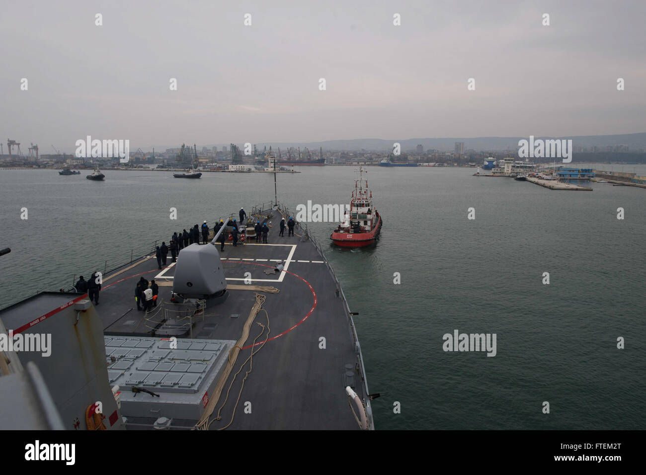 BLACK SEA (Feb. 20, 2015) – A tugboat pulls USS Cole (DDG 67) into Varna, Bulgaria, for a scheduled refueling, Feb. 20, 2015. Cole, an Arleigh Burke-class guided-missile destroyer, homeported in Norfolk, is conducting naval operations in the U.S. 6th Fleet area of operations in support of U.S. national security interests in Europe. Stock Photo