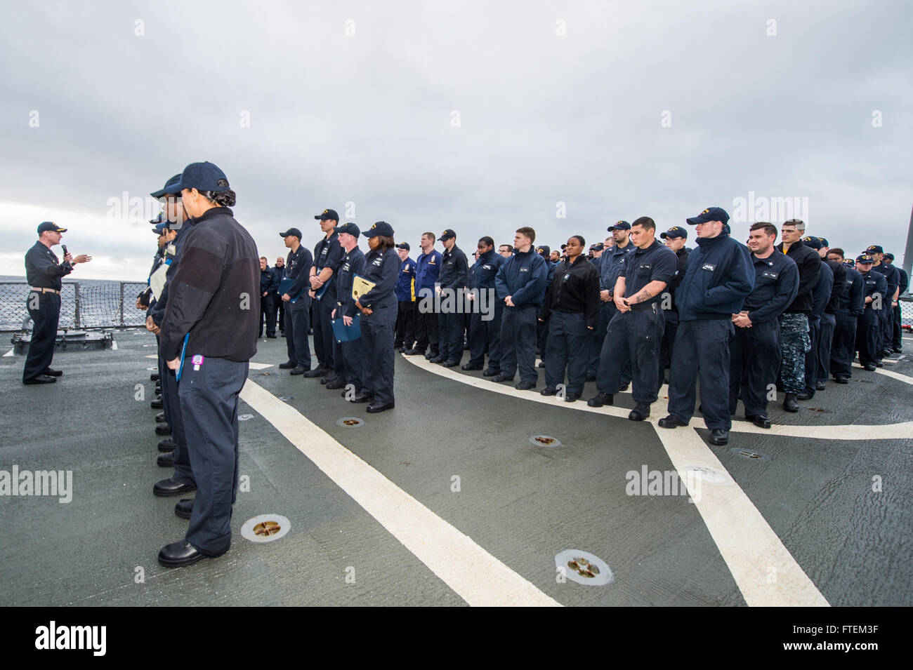 ATLANTIC OCEAN (Feb. 21, 2015) Commanding Officer of USS Laboon (DDG 58), Cmdr. Christopher M. McCallum updates Sailors on upcoming operations during an all-hands call on the flight deck Feb. 21, 2015. Laboon, an Arleigh Burke-class guided-missile destroyer, homeported in Norfolk, is conducting naval operations in the U.S. 6th Fleet area of operations in support of U.S. national security interests in Europe. Stock Photo