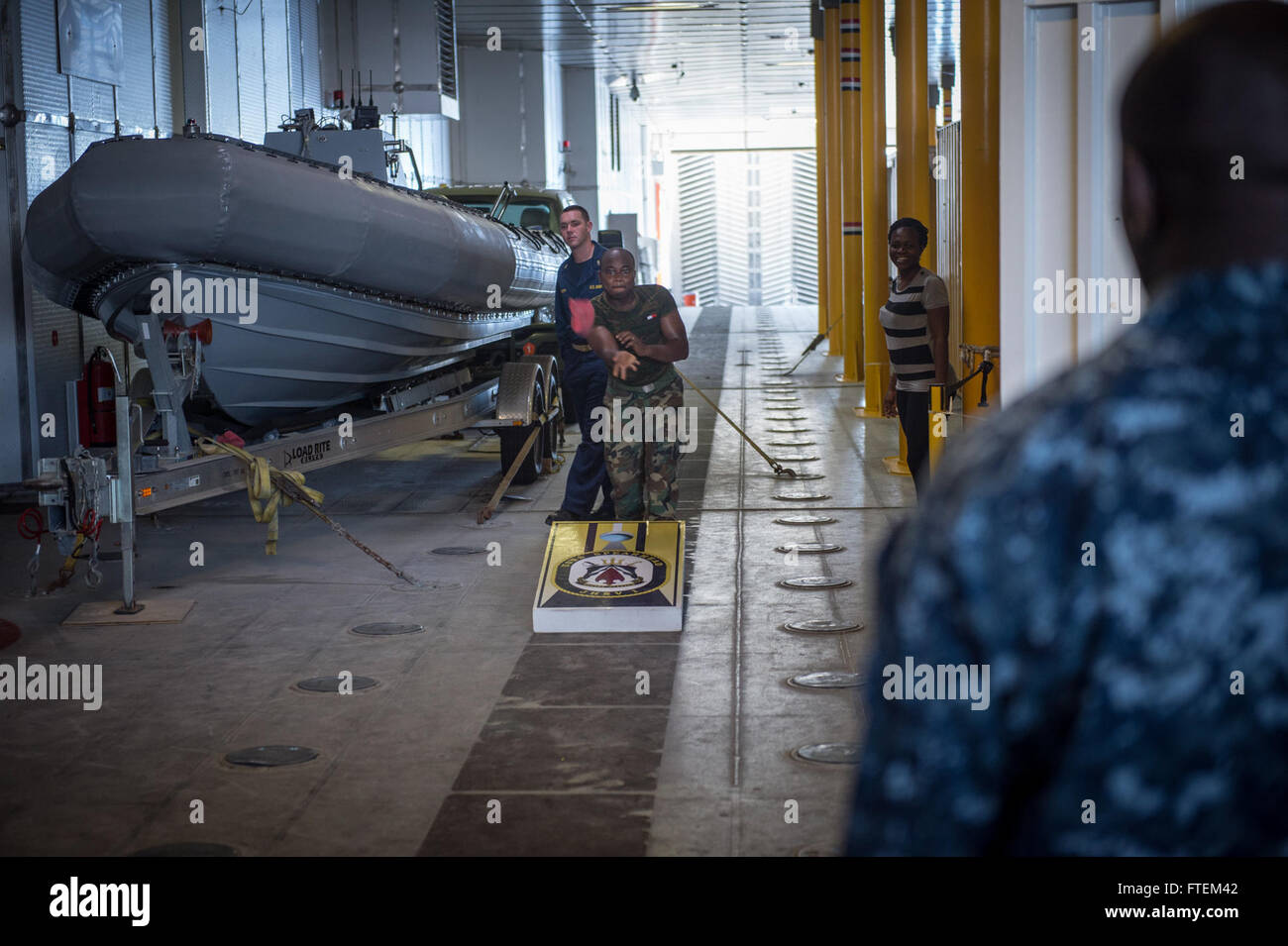 ATLANTIC OCEAN (Feb. 21, 2015) Embarked Ghanaian media participate in a cornhole tournament with U.S. Navy Sailors in the mission bay aboard the Military Sealift Command’s joint high-speed vessel USNS Spearhead (JHSV 1) Feb. 21, 2015. Spearhead is on a scheduled deployment to the U.S. 6th Fleet area of operations to support the international collaborative capacity-building program Africa Partnership Station. Stock Photo