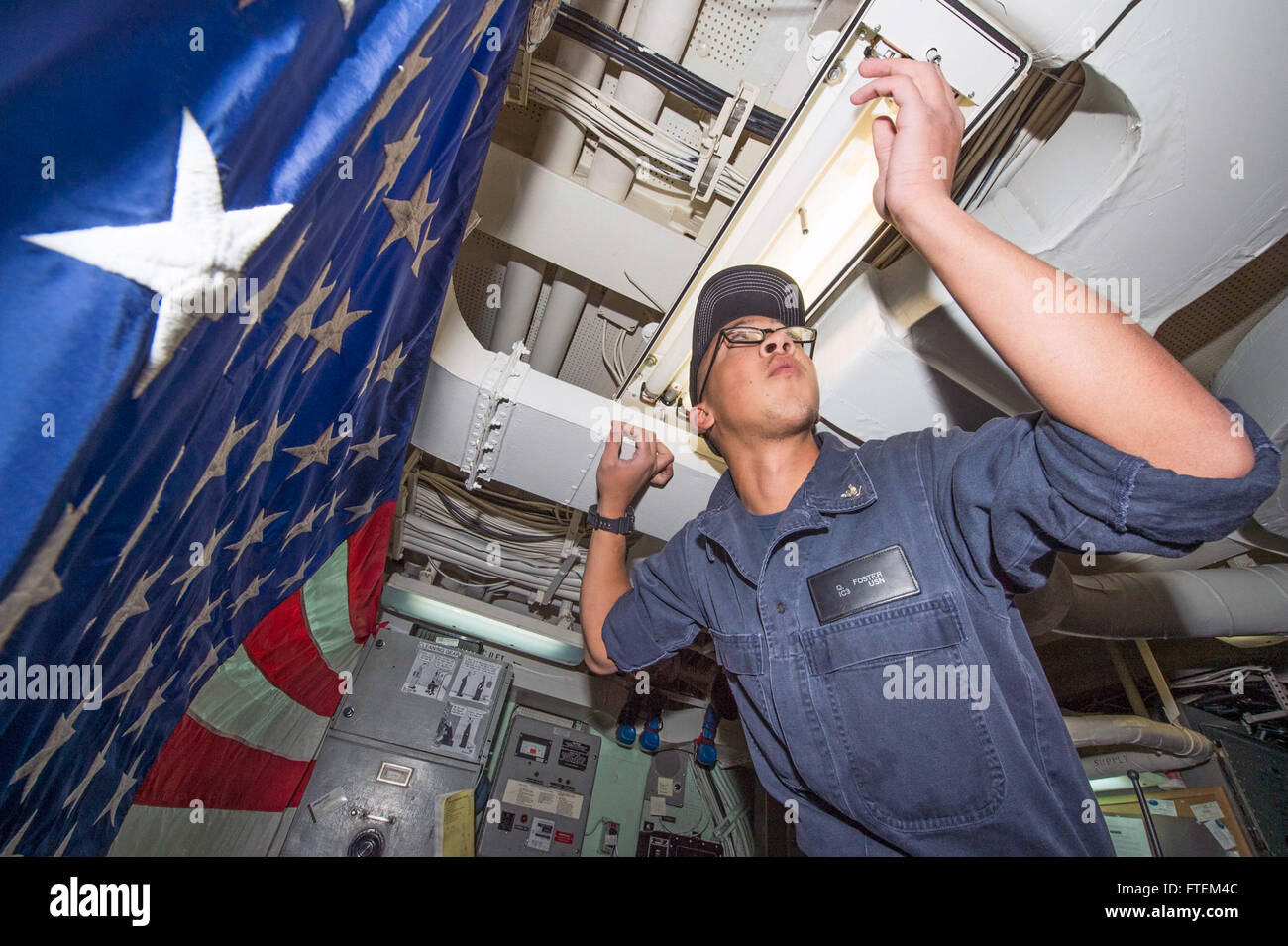 ATLANTIC OCEAN (Feb. 22, 2015) Interior Communications Electrician 3rd Class Quinton Foster, from Grays Creek, Illinois, repairs an overhead light aboard USS Laboon (DDG 58) Feb. 22, 2015. Laboon, an Arleigh Burke-class guided-missile destroyer home ported in Norfolk, is conducting naval operations in the U.S. 6th Fleet area of operations in support of U.S. national security interests in Europe. Stock Photo
