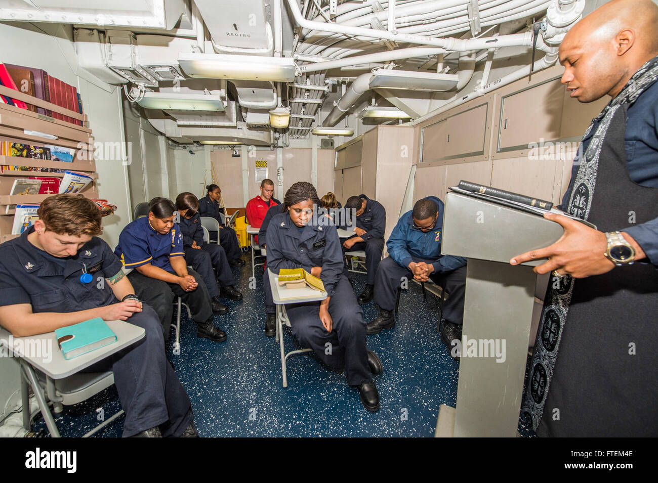 ATLANTIC OCEAN (Feb. 22, 2015) Lt. j. g. Marquis Jones, originally from Fort Lauderdale, leads Sailors in Sunday Mass aboard USS Laboon (DDG 58) Feb. 22, 2015. Laboon, an Arleigh Burke-class guided-missile destroyer home ported in Norfolk, is conducting naval operations in the U.S. 6th Fleet area of operations in support of U.S. national security interests in Europe. Stock Photo
