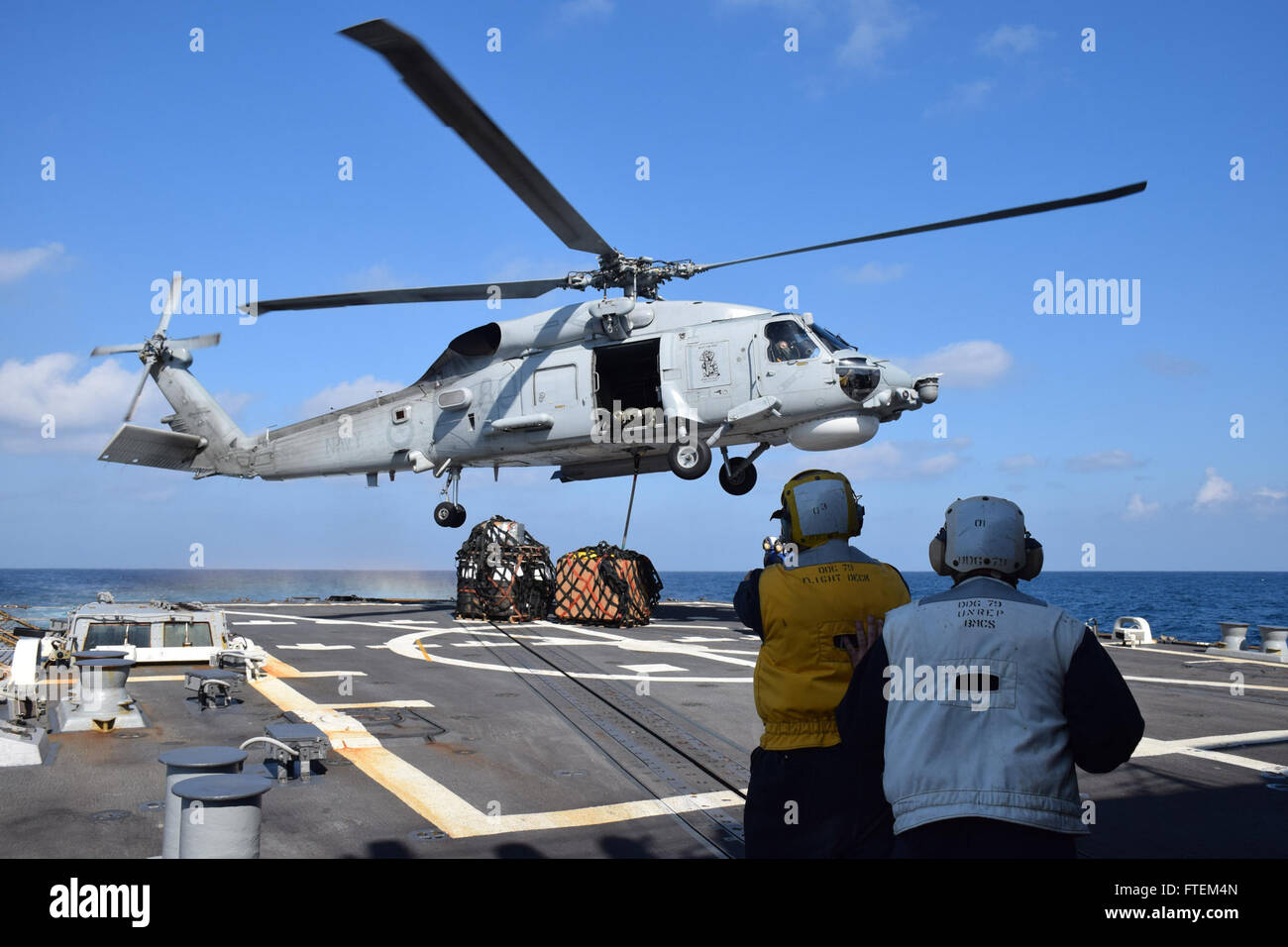 HORN OF AFRICA (Feb. 23, 2015) USS Oscar Austin (DDG 79) conducts a vertical replenishment with an SH-60F Seahawk embarked aboard the Royal Australian navy ship HMAS Success (OR 304) Feb. 23, 2015. Oscar Austin, an Arleigh Burke-class guided-missile destroyer, homeported in Norfolk, is conducting naval operations in the U.S. 6th Fleet area of operations in support of U.S. national security interests in Europe and Africa. Stock Photo