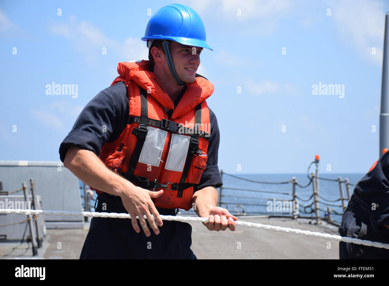 HORN OF AFRICA (Feb. 23, 2015) Information Systems Technician 3rd Class Scott Royal helps heave around on a line aboard USS Oscar Austin (DDG 79) in preparation for an underway replenishment with the Royal Australian navy ship HMAS Success (OR 304) Feb. 23, 2015. Oscar Austin, an Arleigh Burke-class guided-missile destroyer, homeported in Norfolk, is conducting naval operations in the U.S. 6th Fleet area of operations in support of U.S. national security interests in Europe and Africa. Stock Photo