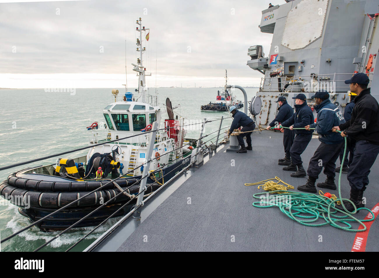 Spain (Feb. 23, 2015) Sailors aboard USS Laboon (DDG 58) heave a line connected to a tug boat as the ship makes preparations to moor at Naval Station Rota, Spain, Feb. 23, 2015. Laboon, an Arleigh Burke-class guided-missile destroyer, homeported in Norfolk, is conducting naval operations in the U.S. 6th Fleet area of operations in support of U.S. national security interests in Europe. Stock Photo
