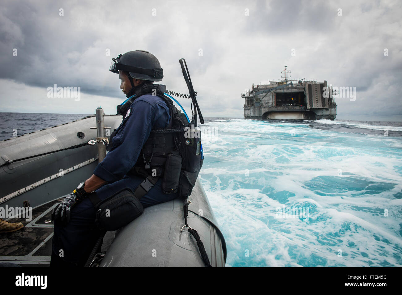 ATLANTIC OCEAN (Feb. 23, 2015) Maritime Enforcement Specialist 3rd Class Wilbur McKesson waits aboard a rigid hull inflatable boat as it approaches the Military Sealift Command’s joint high-speed vessel USNS Spearhead (JHSV 1) during Africa Maritime Law Enforcement Partnership Feb. 23, 2015. Spearhead is on a scheduled deployment to the U.S. 6th Fleet area of operations in support of the international collaborative capacity-building program Africa Partnership Station. Stock Photo