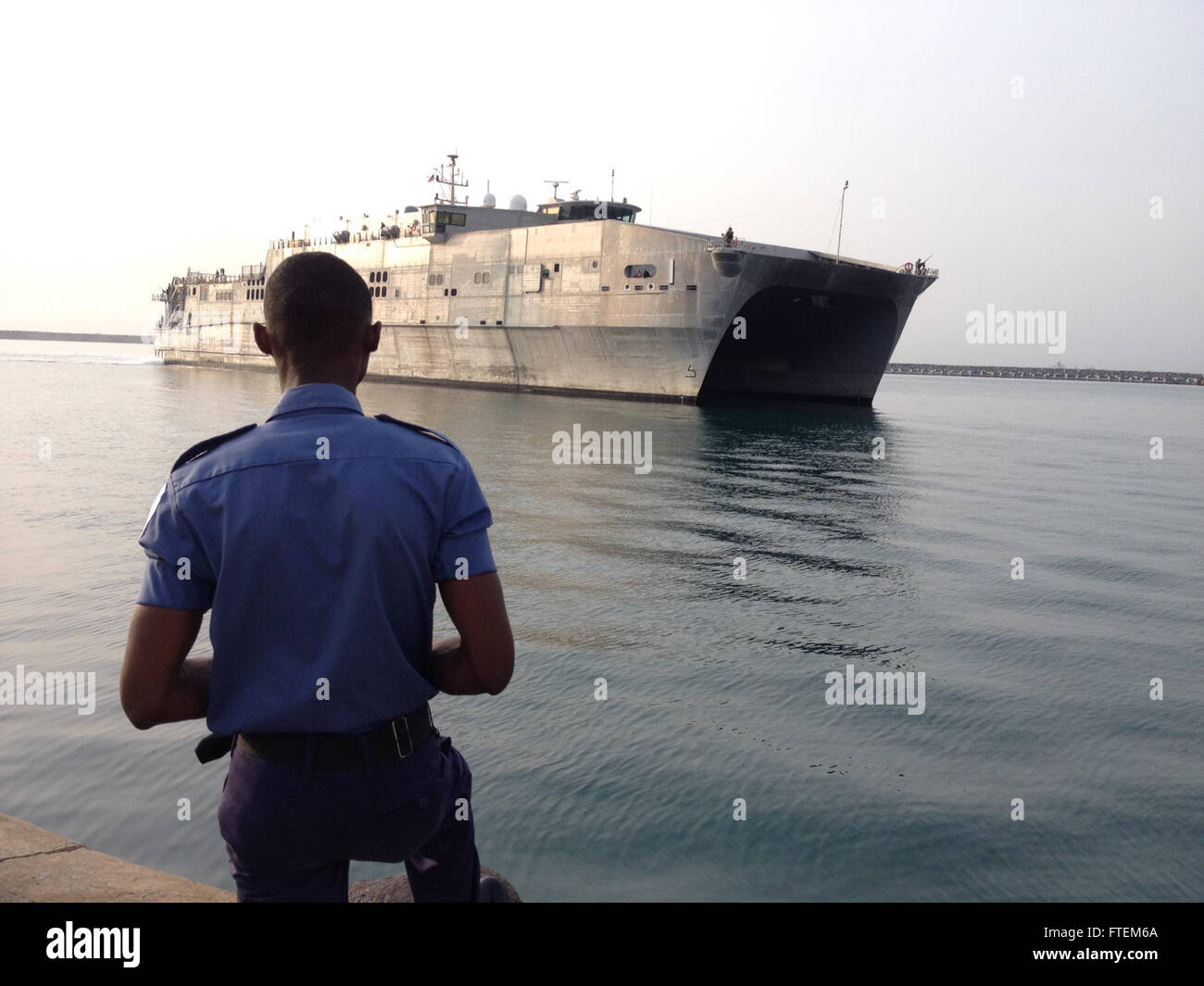 SECONDI NAVAL BASE, Ghana (Feb. 24, 2015) A Ghanaian military member stands by as the Military Sealift Command's joint high-speed vessel USNS Spearhead (JHSV 1) moors at Sekondi Naval Base, Ghana, after completing Africa Maritime Law Enforcement Partnership operations Feb. 24, 2015. Spearhead is on a scheduled deployment to the U.S. 6th Fleet area of operations in support of the international collaborative capacity-building program Africa Partnership Station. Stock Photo