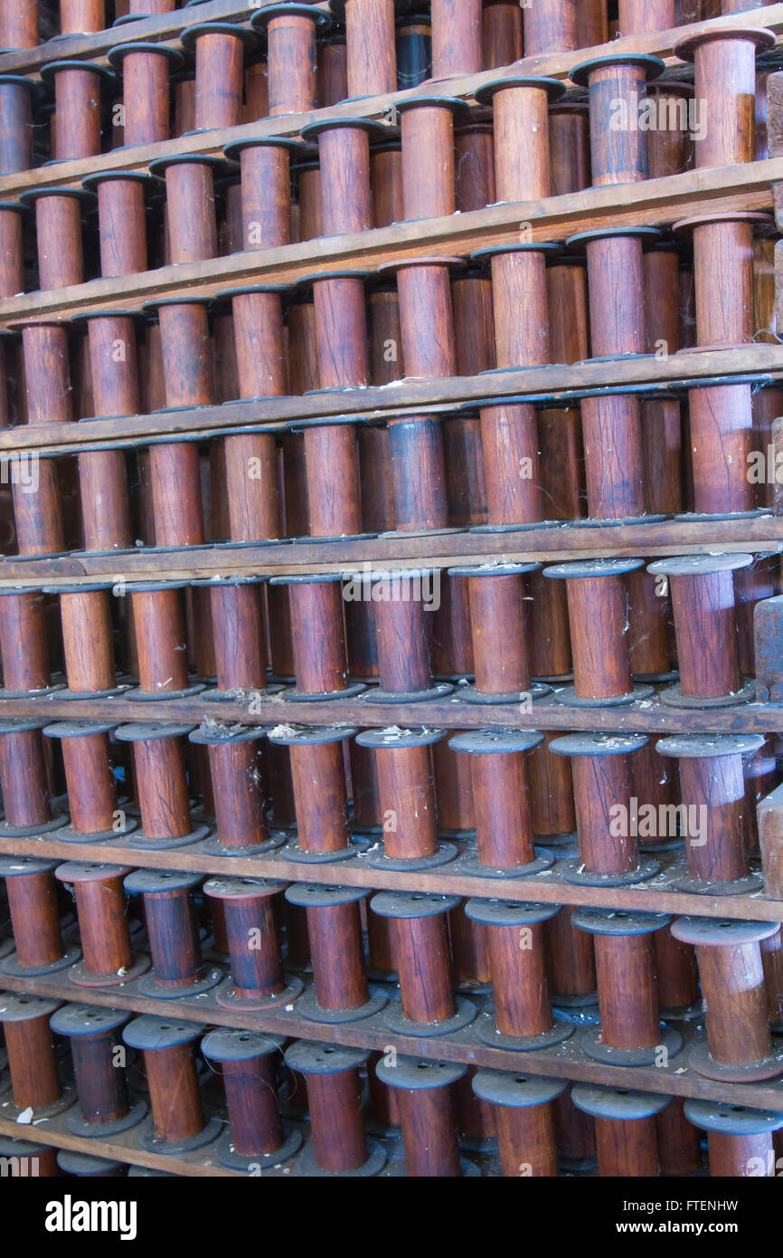 Racks of empty wooden spools in turn of the century silk throwing factory. Stock Photo