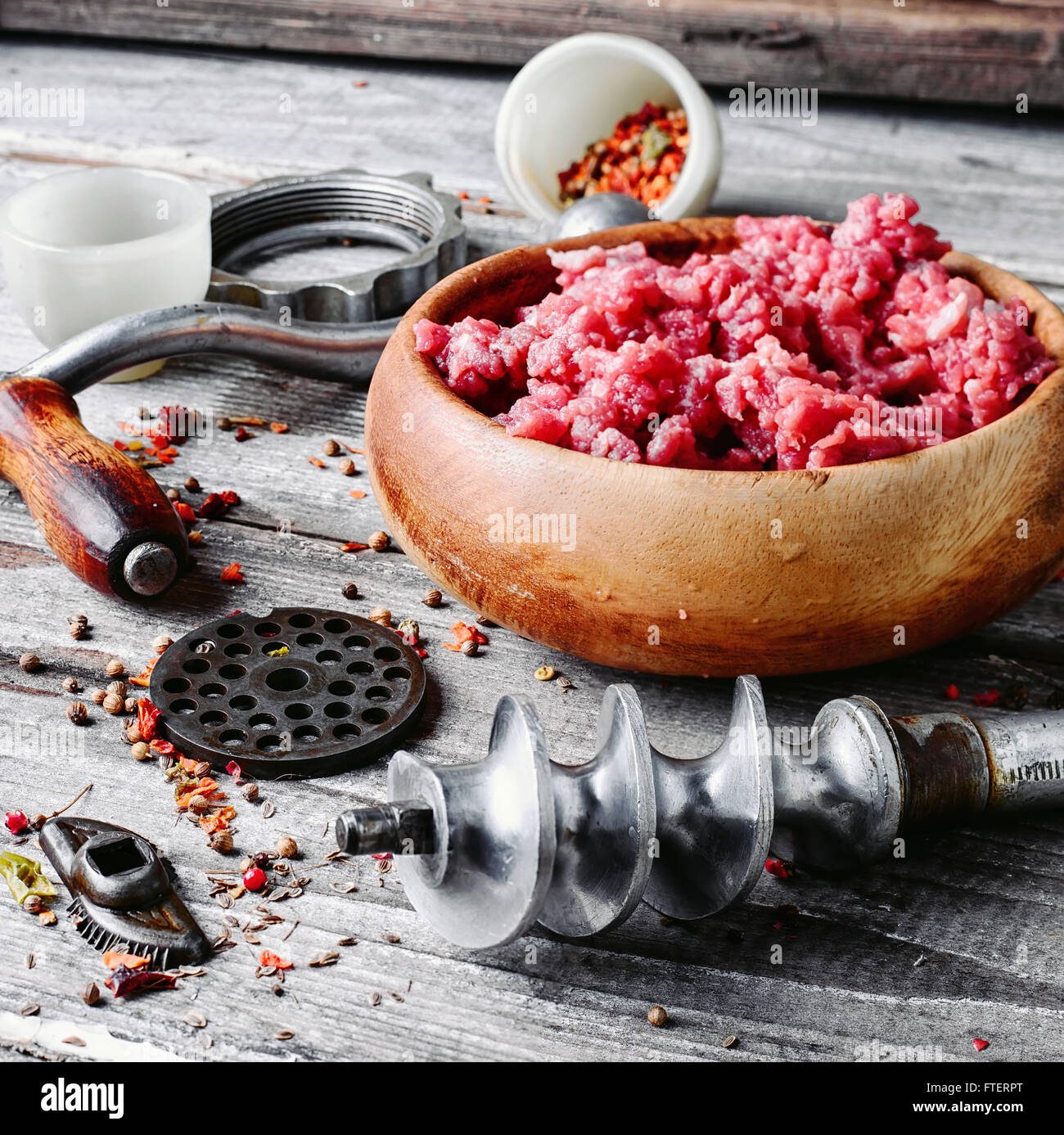 Wooden dish, with meat and parts of the disassembled grinder Stock Photo